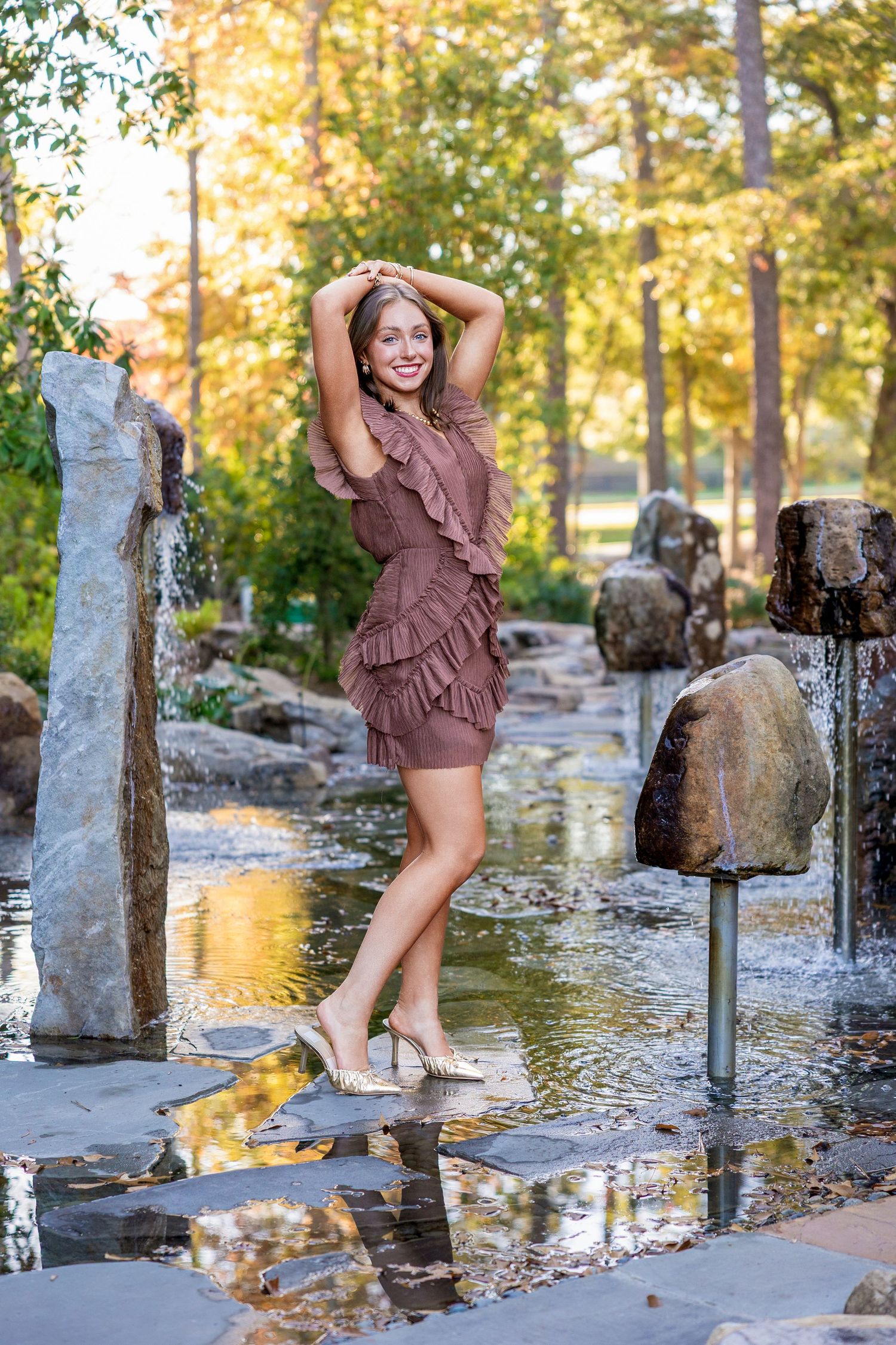 A series of outdoor portrait photos taken near a water feature with stone pillars at golden hour.