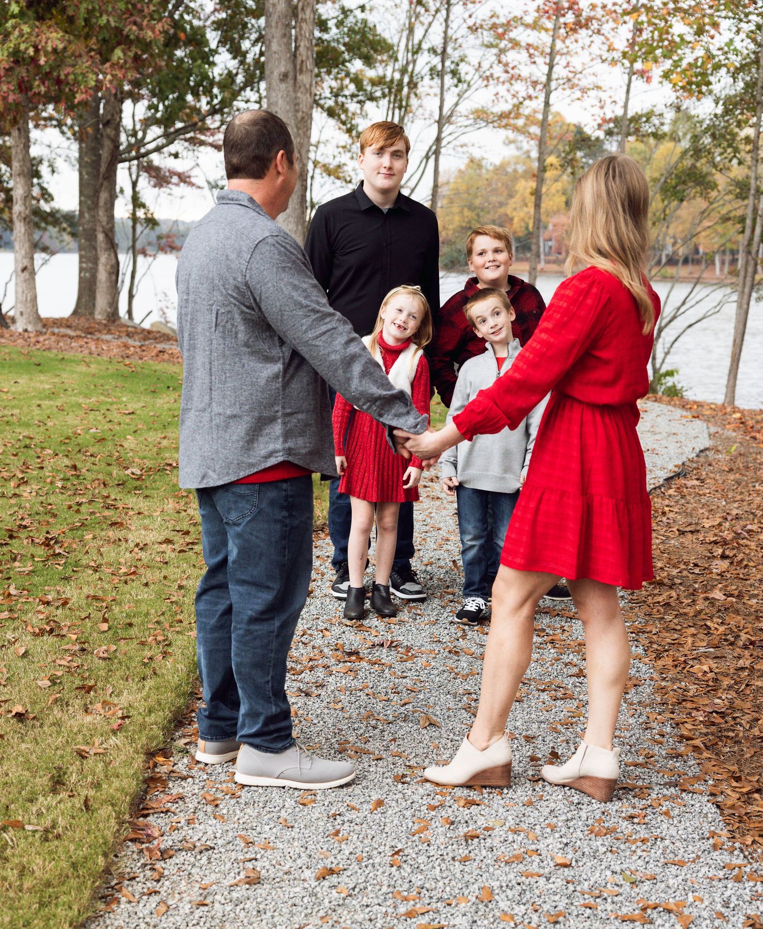 Family walking together on gravel path during autumn afternoon.
