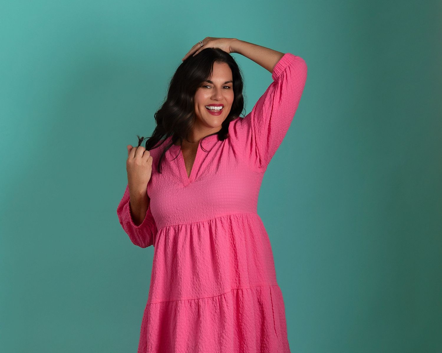 A series of photos showing a person twirling and dancing in a bright pink dress against a teal background.