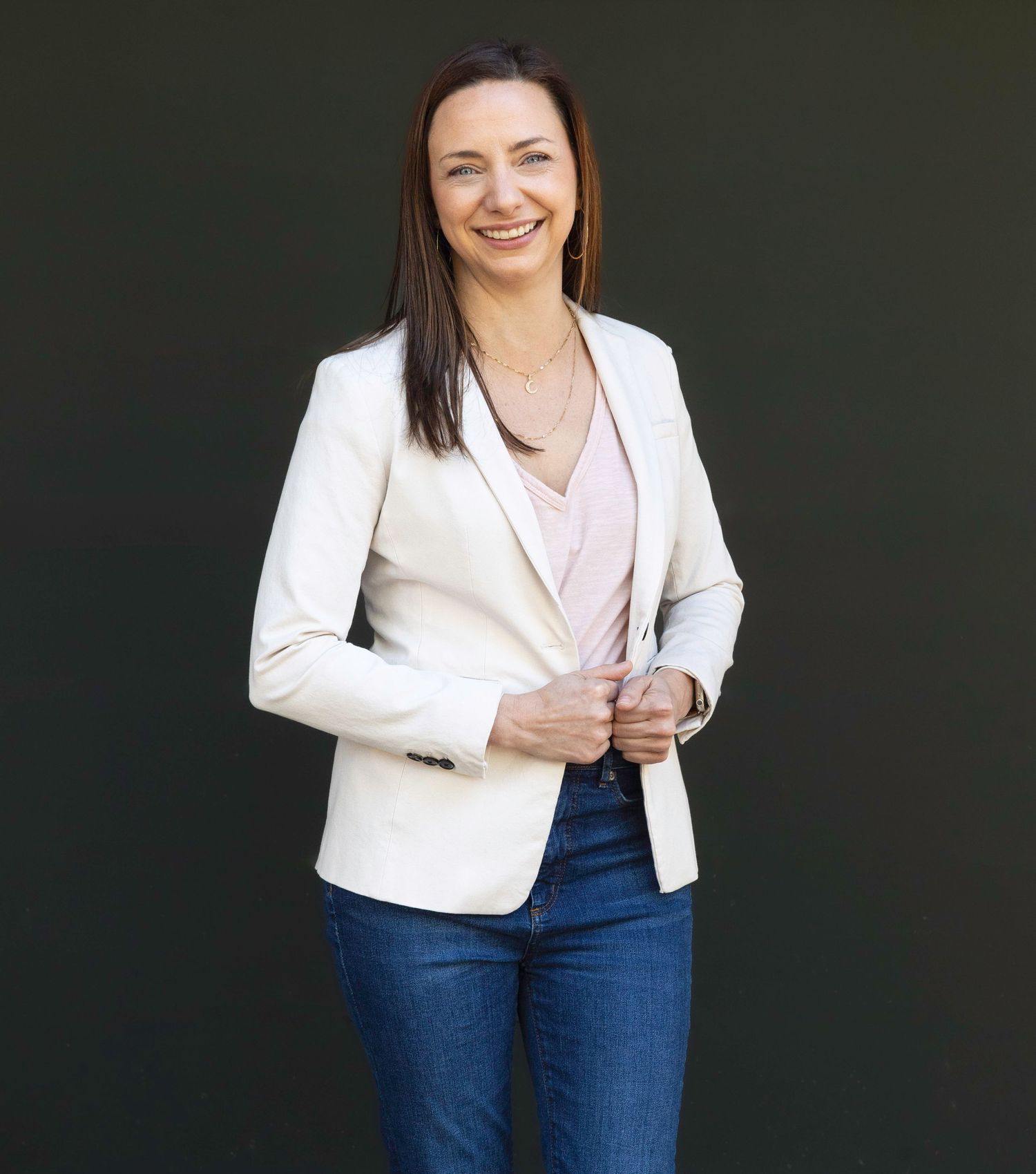 Professional portrait series featuring white blazer and dark jeans against black background.
