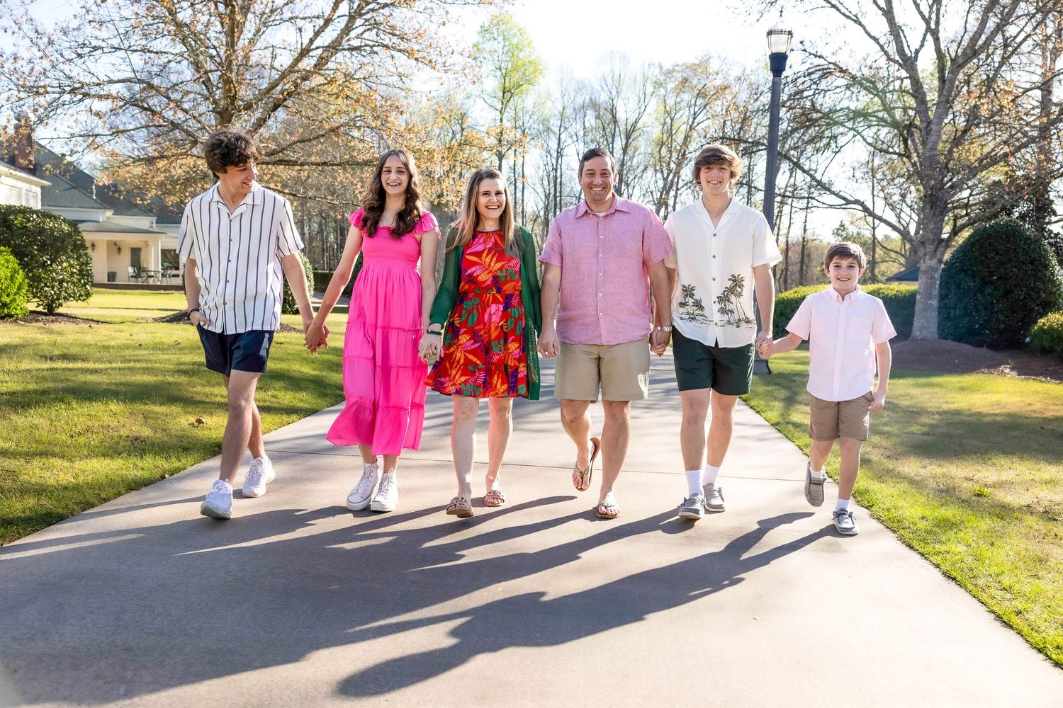 Group walking together on sidewalk during golden hour sunset.