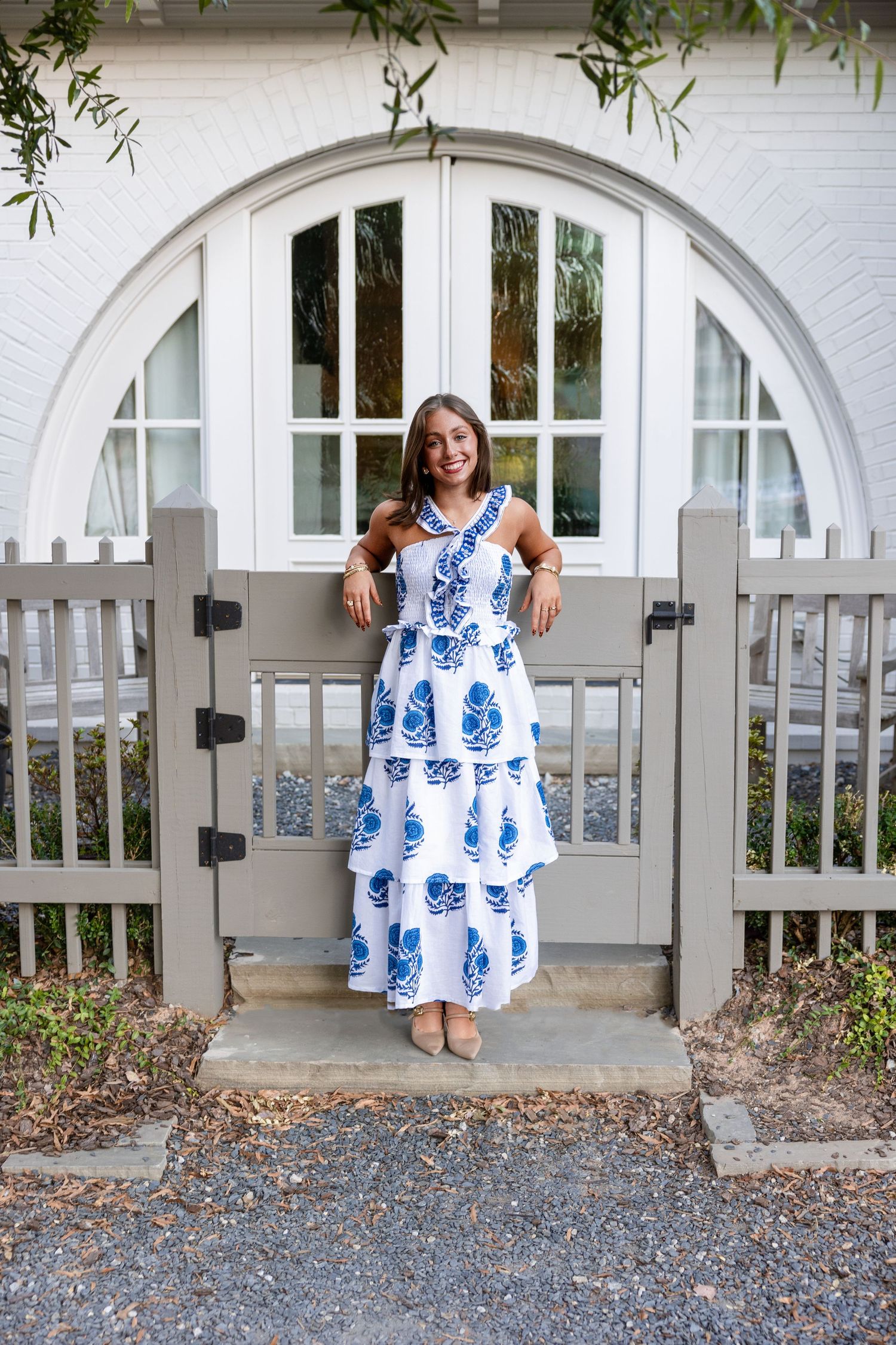 A sequence showing a white and blue patterned dress swaying while sitting on a wooden gate.