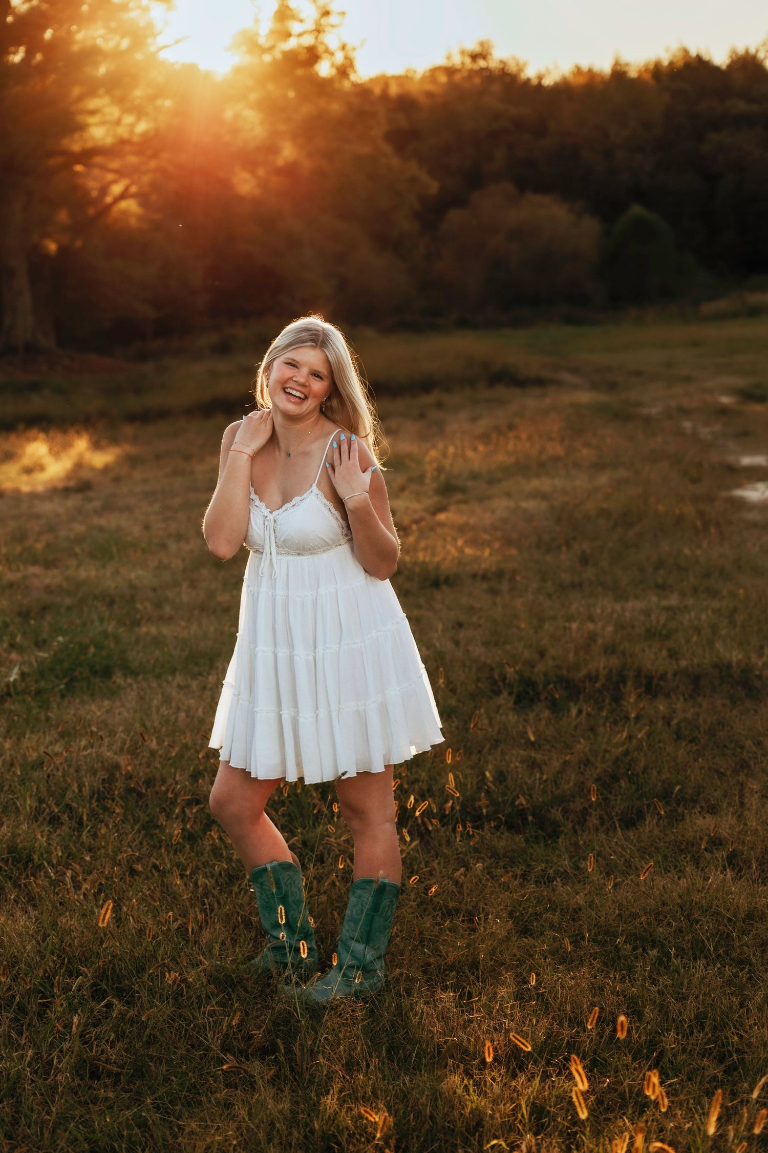 Sunset photoshoot in field wearing white dress and green boots.