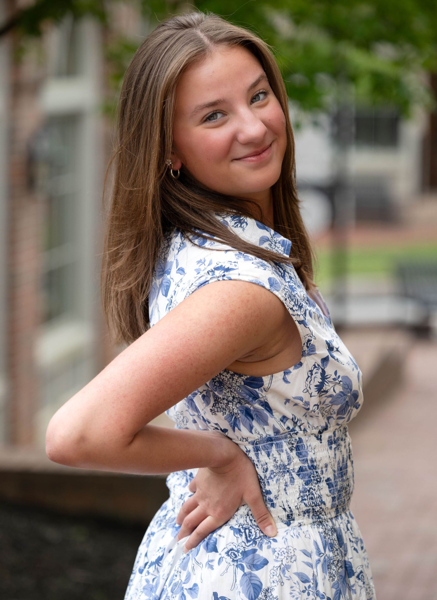 A series of five photos showing a person in a blue and white floral dress posing outdoors against a blurred background.