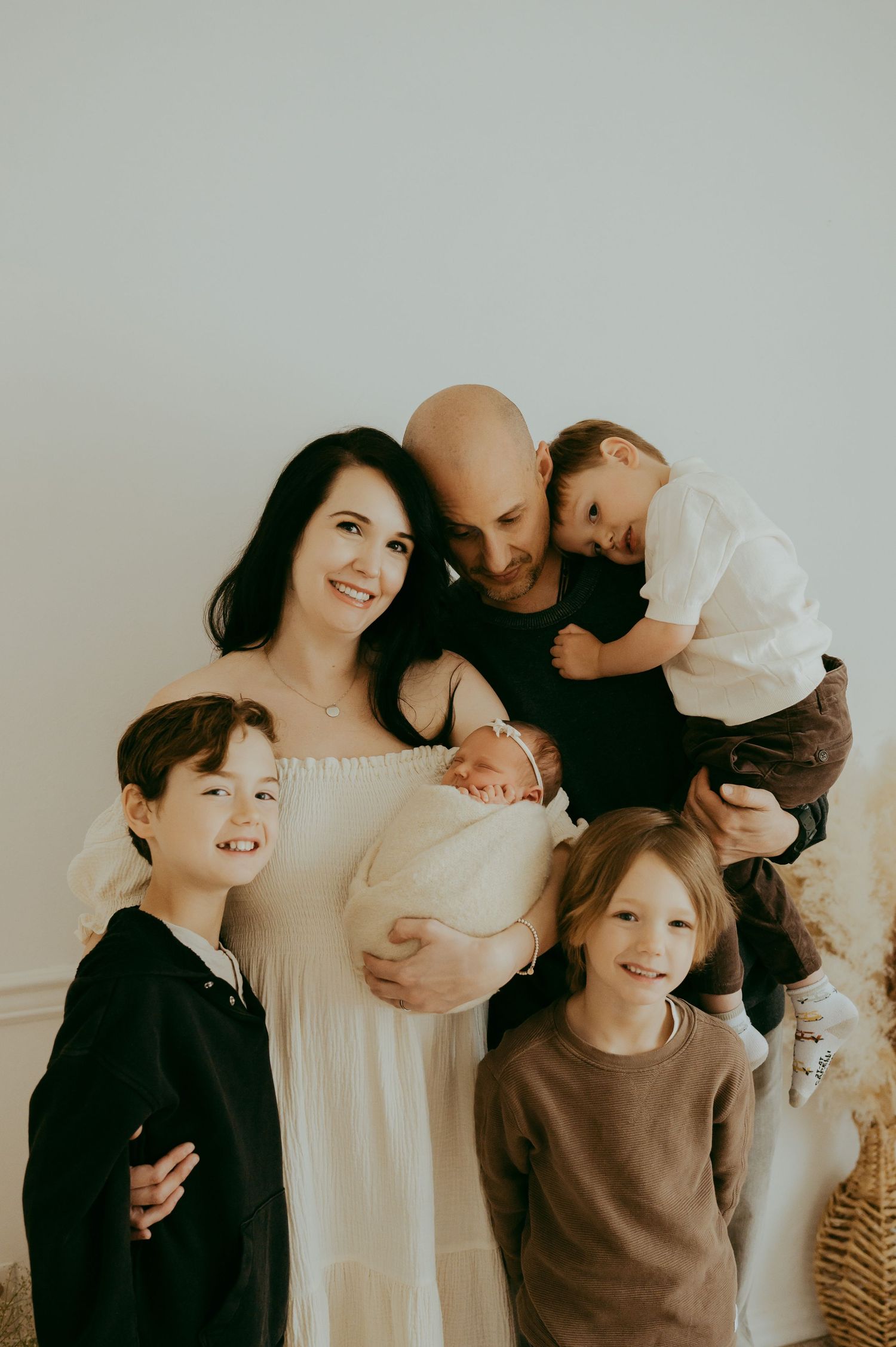 A family group shares joyful moments together in a series of candid photographs against a light background.