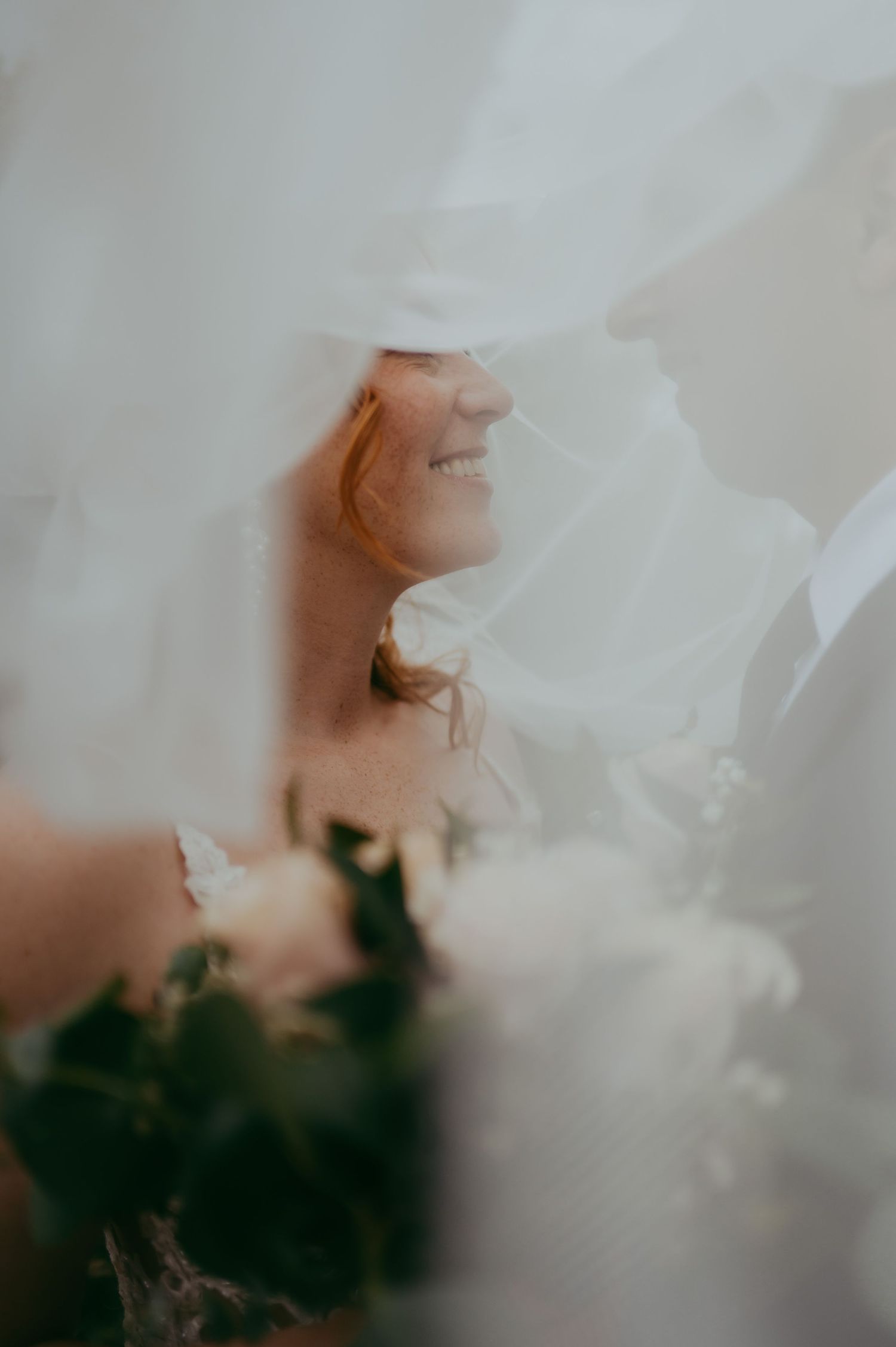 Soft white chiffon fabric creates an ethereal and dreamy effect against a blurred dark background.