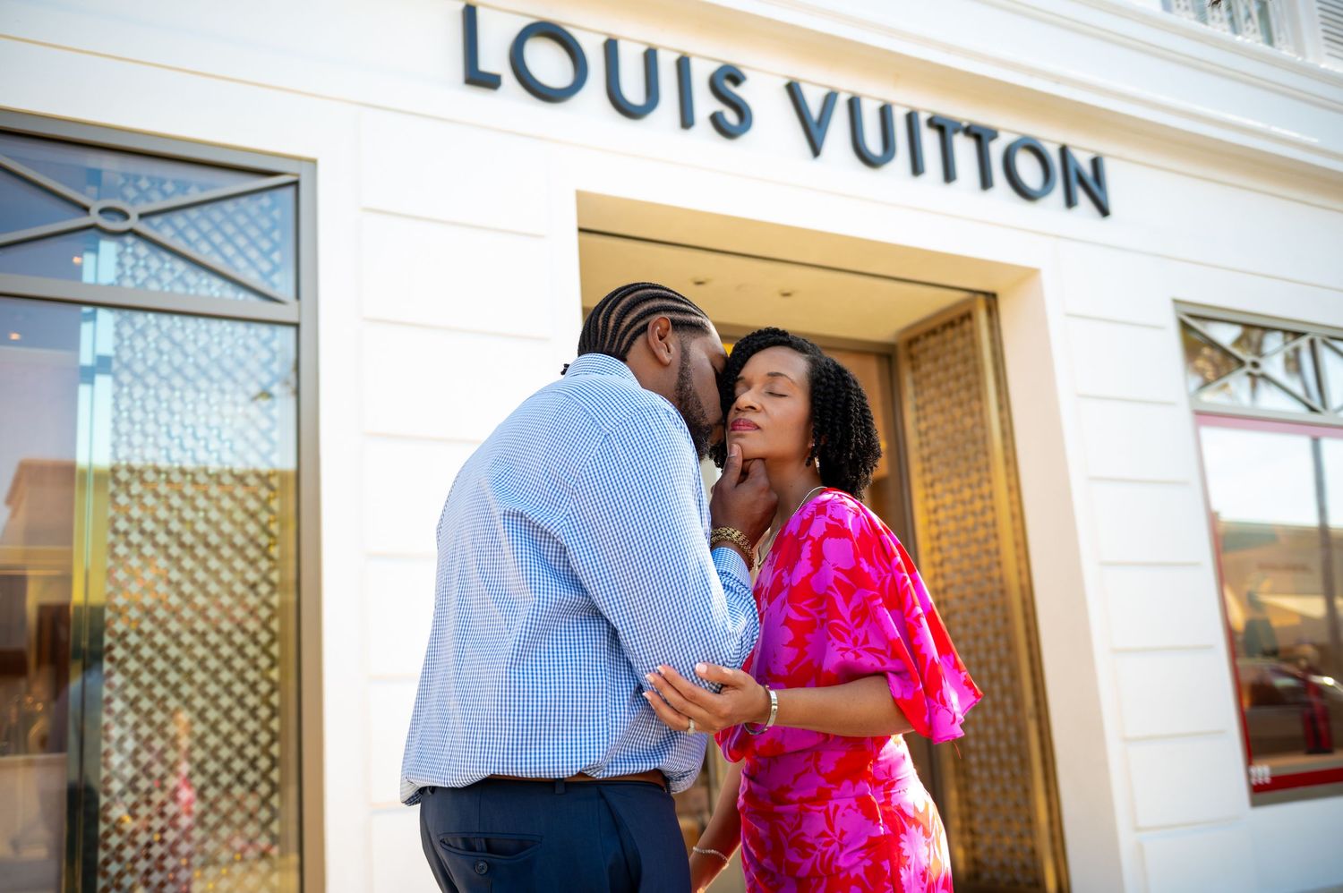 This man kisses his fiancée in front of the Louis Vuitton store at the Shops on Worth Avenue during their Worth Avenue engagement session.