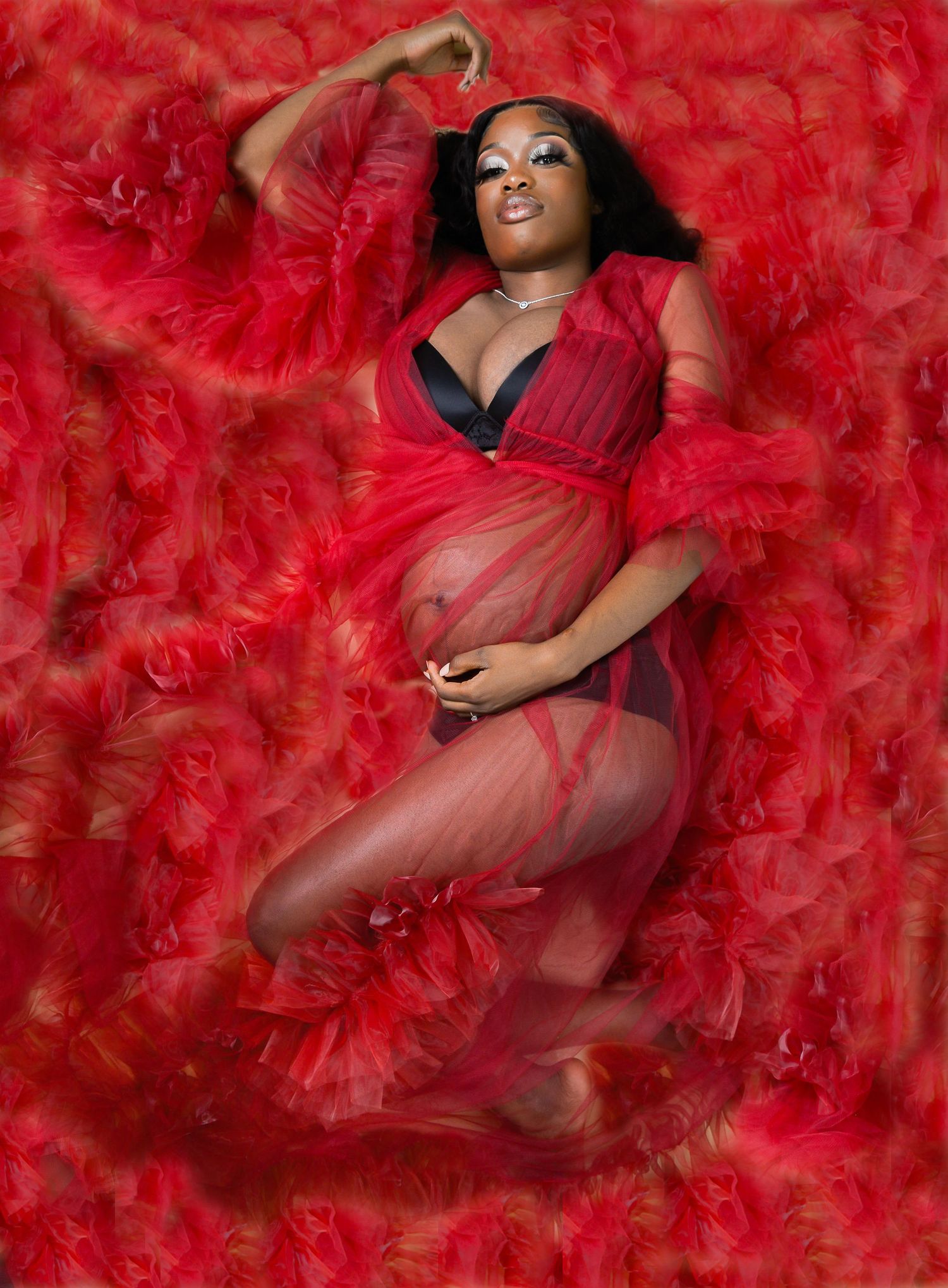 Mother-to-be lies on feathers during her maternity session in Cocoa, Florida.