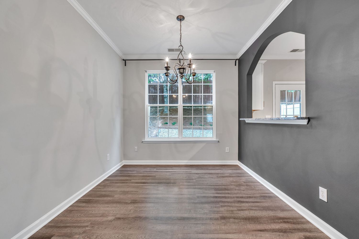 Elegant dining space with arched entryway, hardwood floors, and pendant lighting creating a sophisticated atmosphere.
