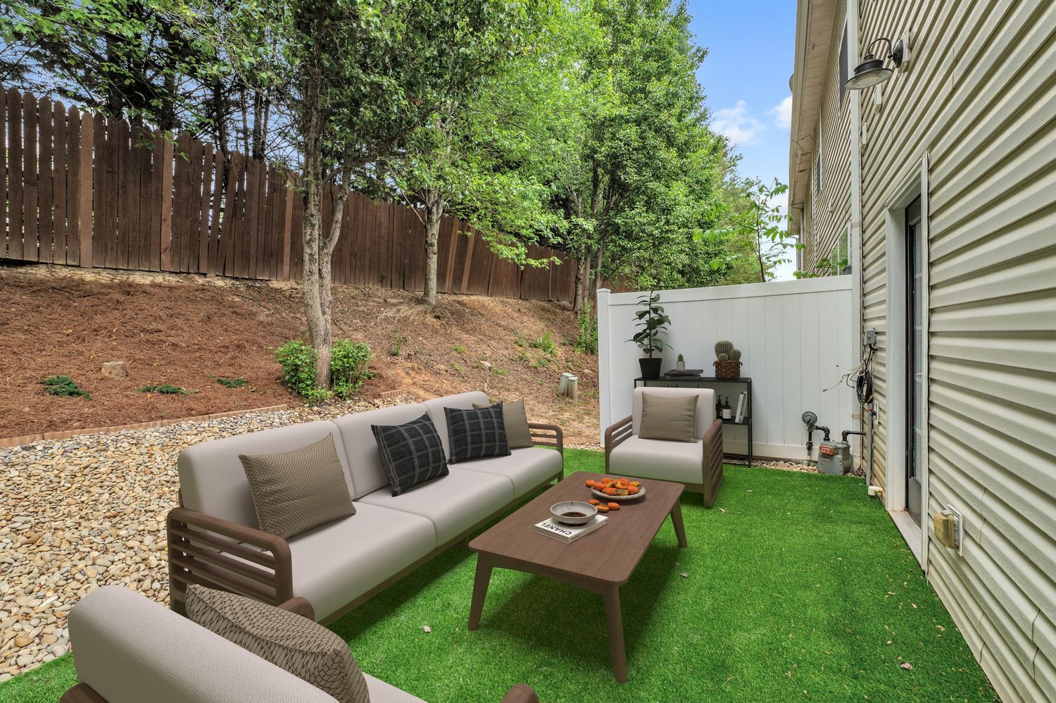 Outdoor patio area with modern furniture and artificial grass.