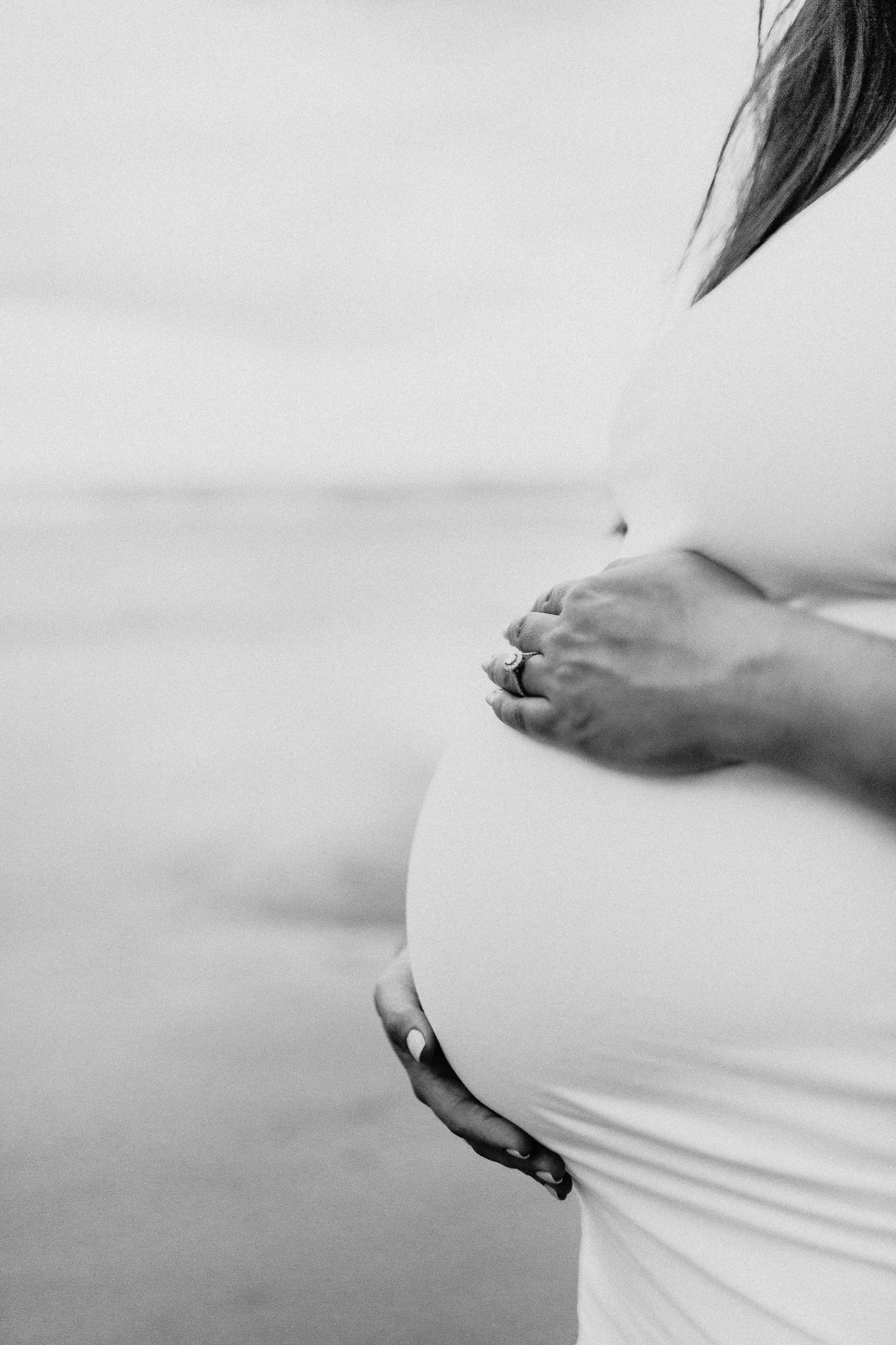 Series of black and white maternity photos showing a growing pregnant belly.