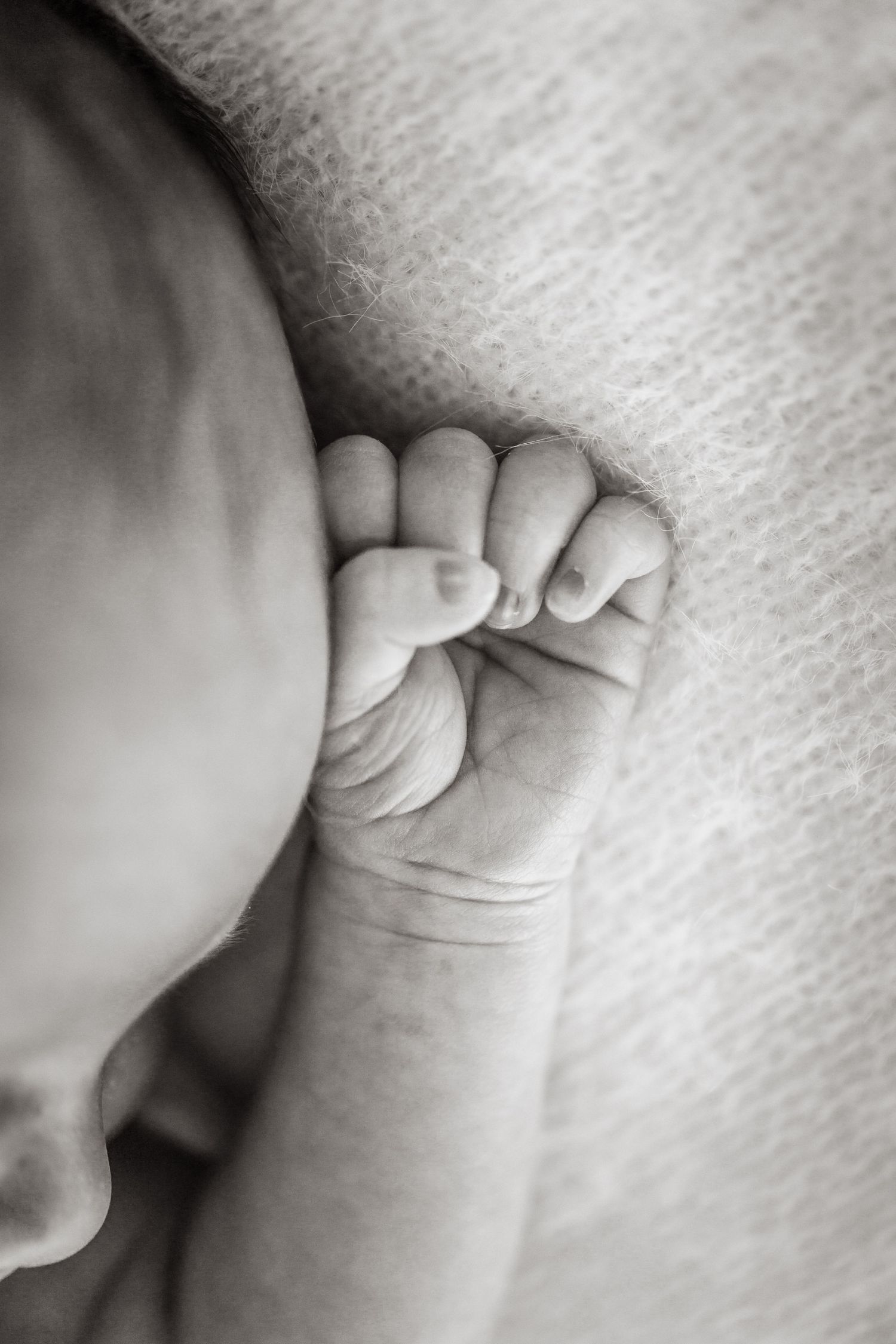 Close-up macro shots of delicate baby fingers and hands in black and white.