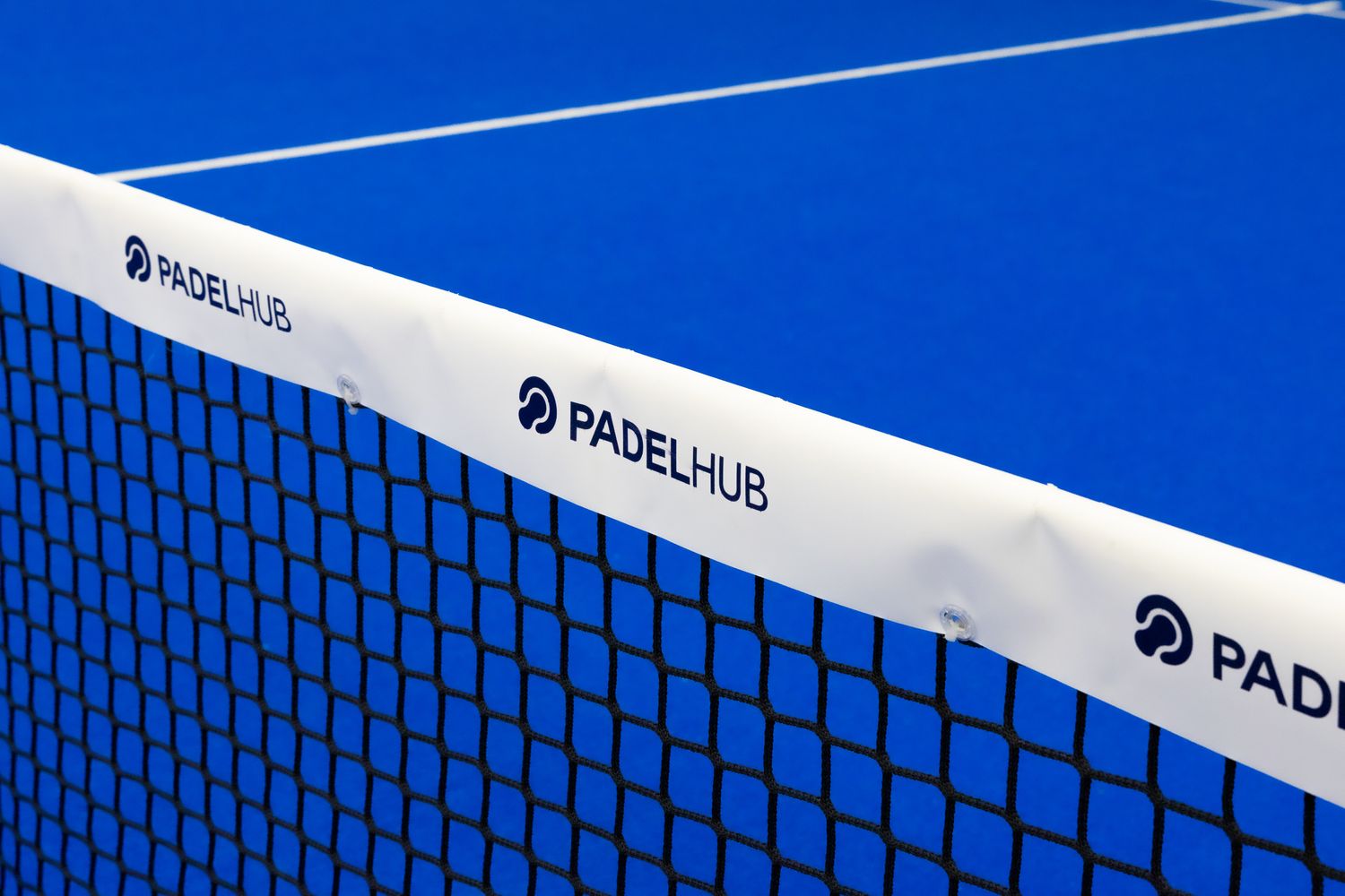 PadelHub branded white net stretched across a vibrant blue professional padel tennis court.