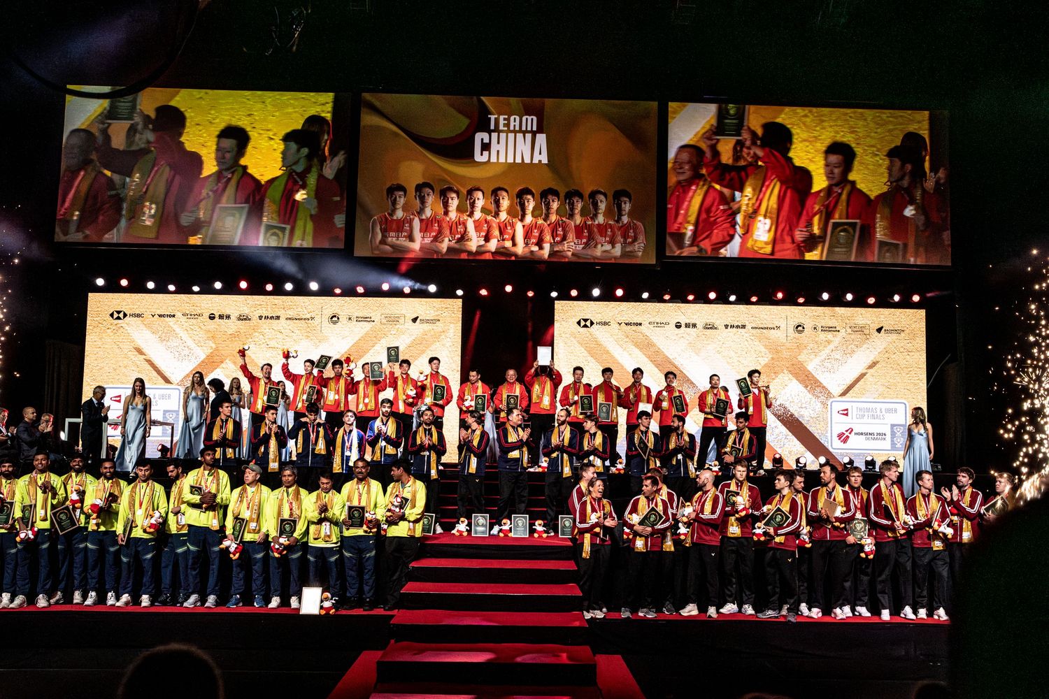 Team China and other nations gather on stage during badminton world championship closing ceremony.