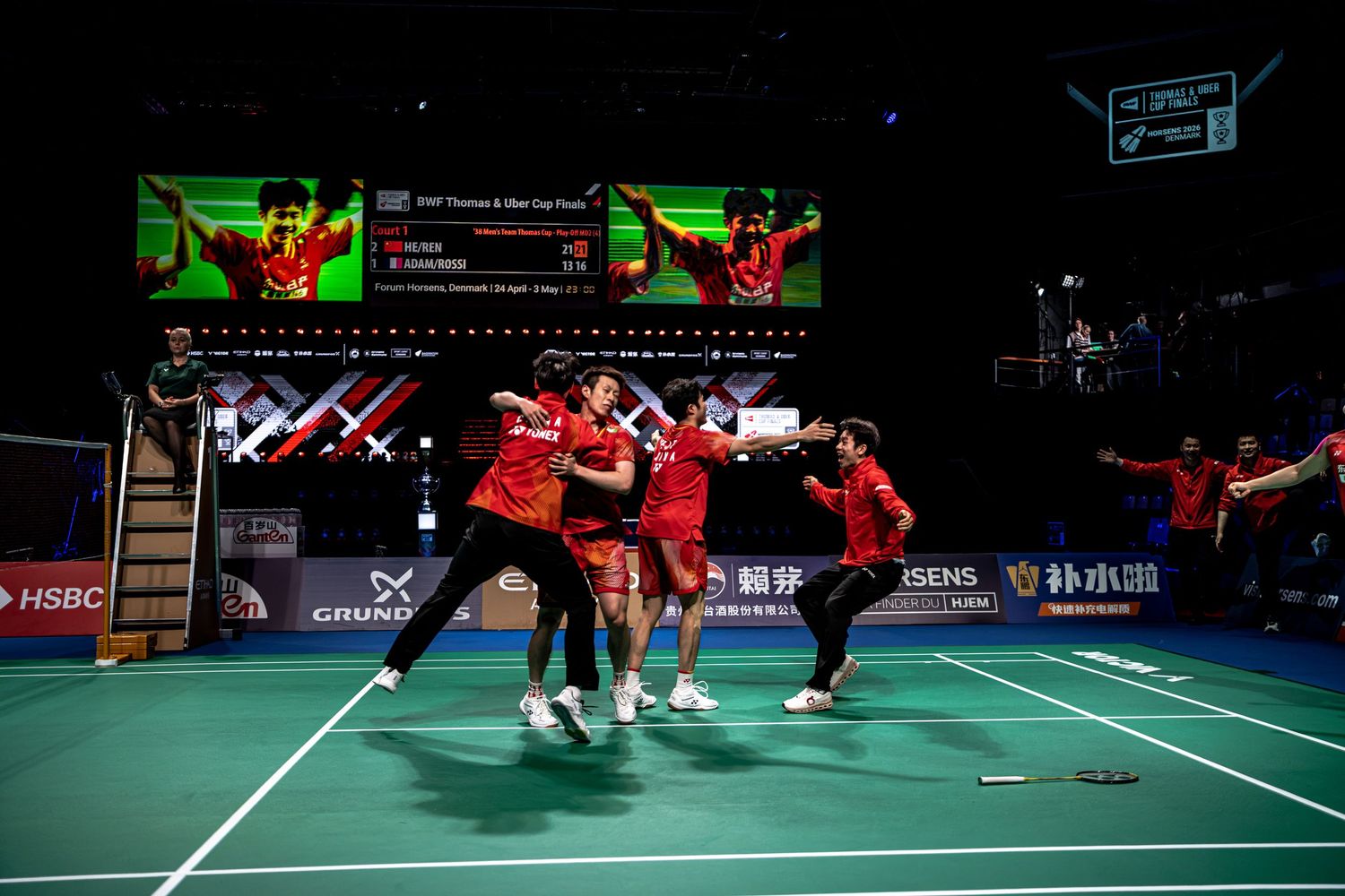 Chinese national badminton team erupting in joyful celebration after winning BWF Thomas Cup Finals in Horsens.