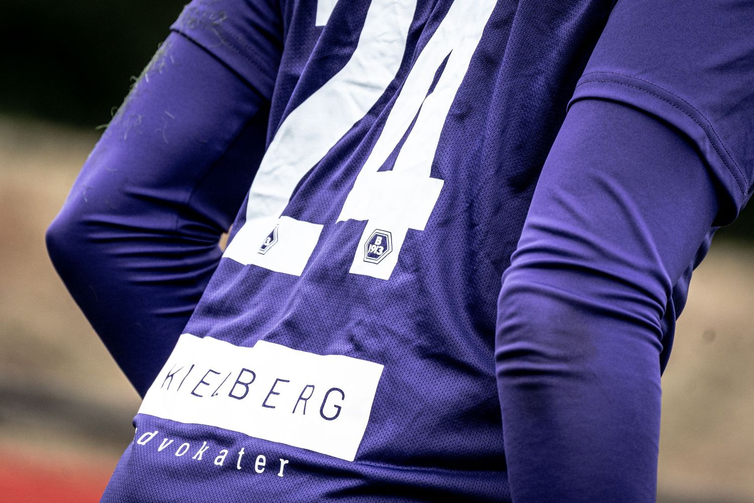 Close-up of a blue sports jersey with number 24 and HEIBERG sponsor logo on the back.