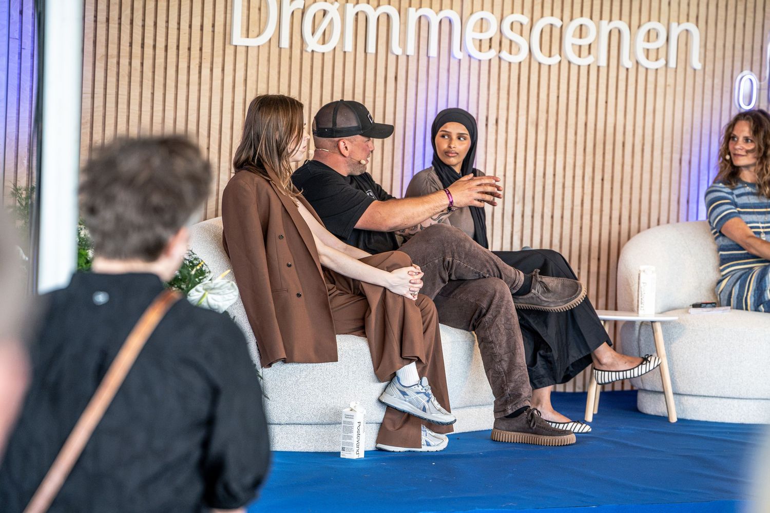 Three panelists engaged in lively discussion at the Nordea Drømmescenen outdoor stage event.