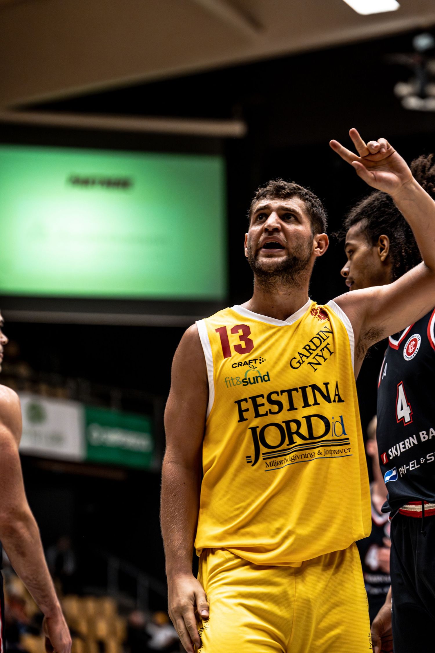Basketball player number 13 in yellow Festina Jord jersey looking up during game.
