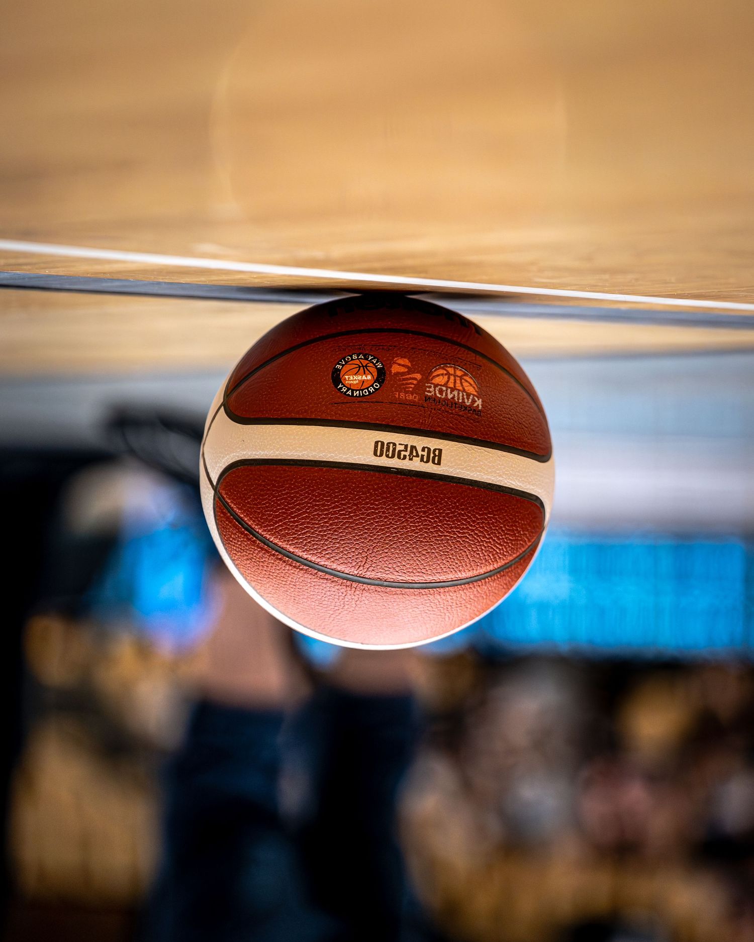 Close-up of official Molten BG4500 basketball resting on glass court surface.