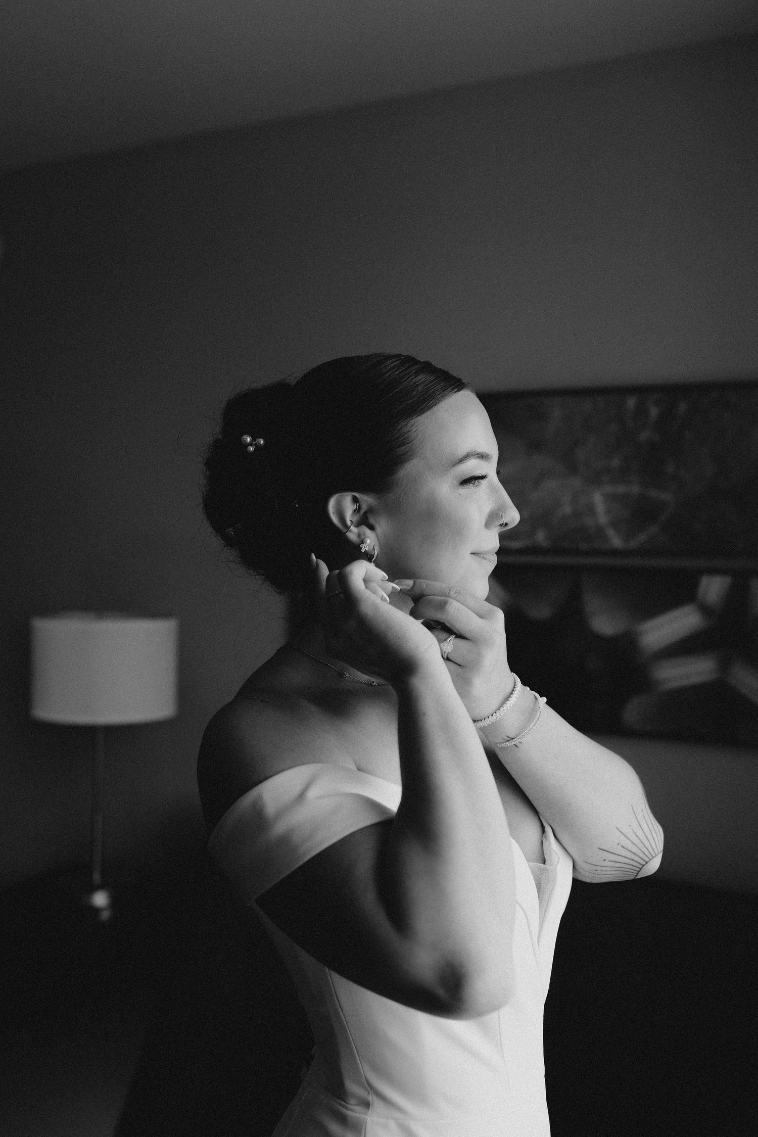 a bride putting her earrings on looking away