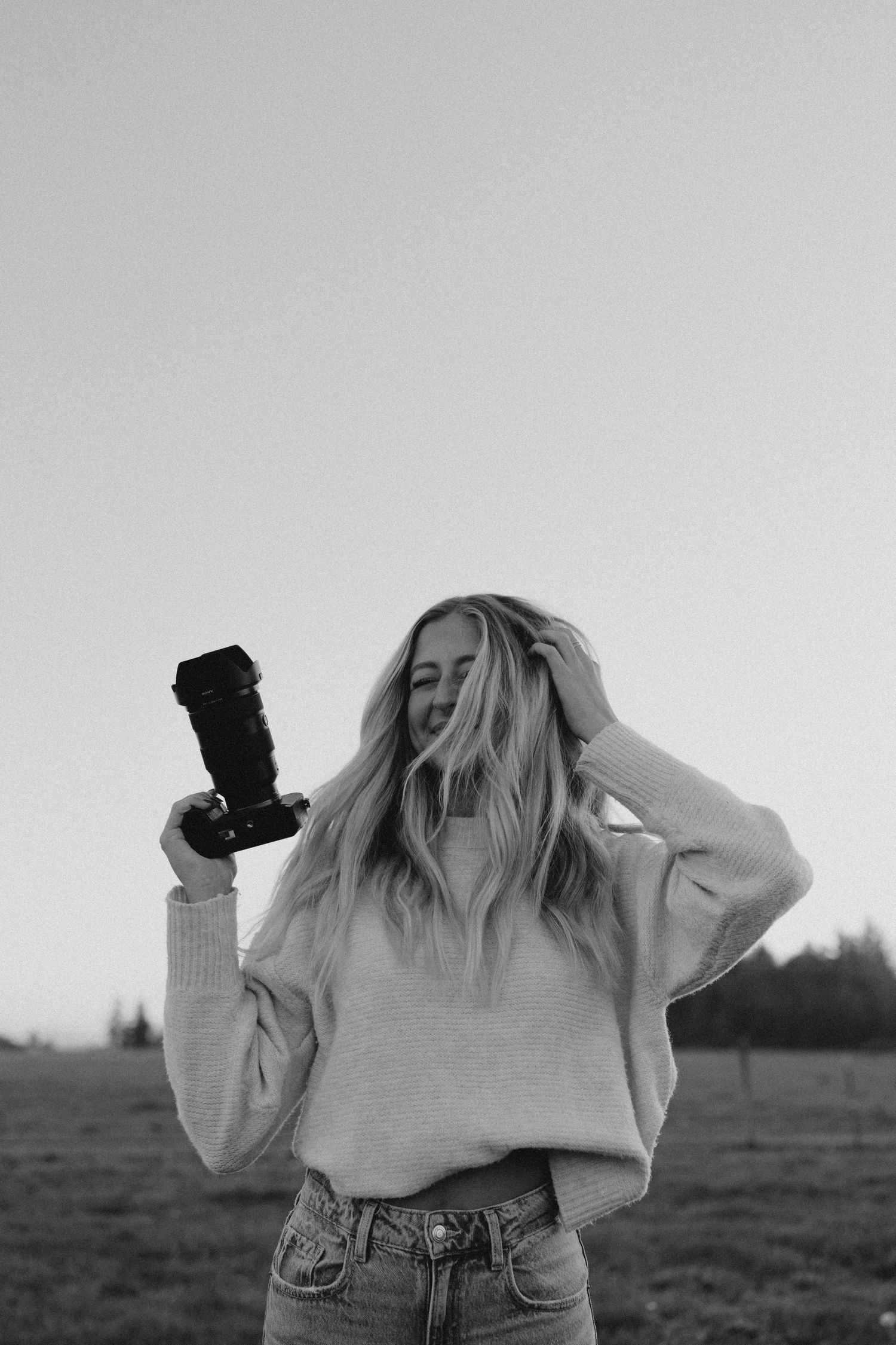 a photographer holding her camera looking to the side
