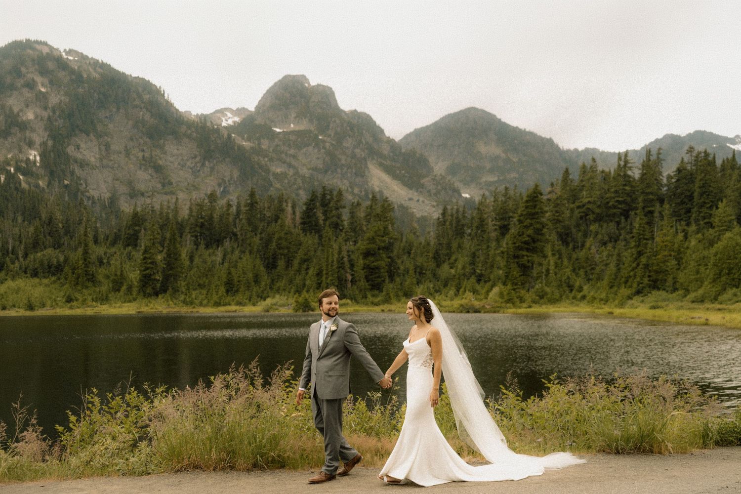 a bride and groom walking in a mountain landscape