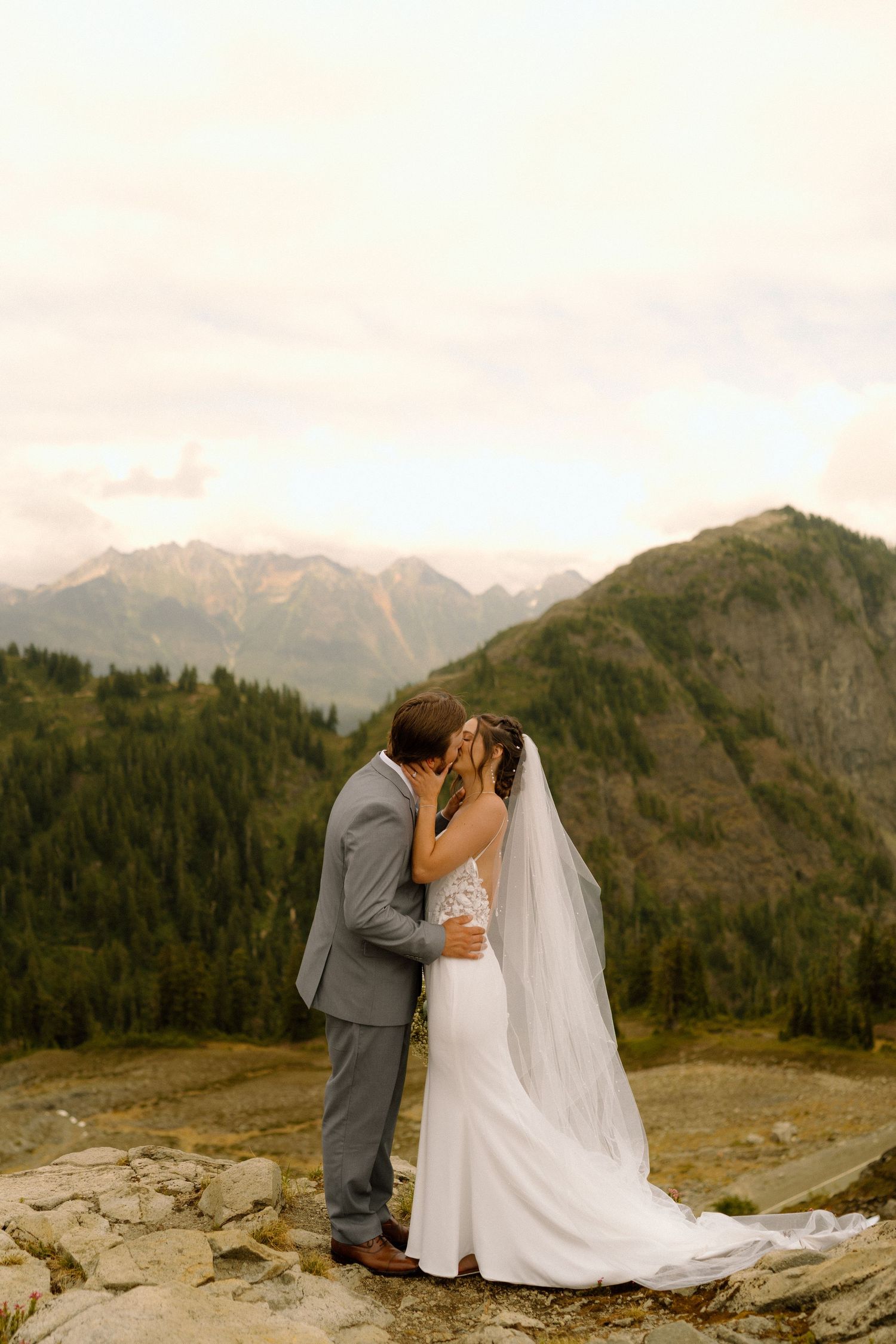 bride and groom kissing in the mountains