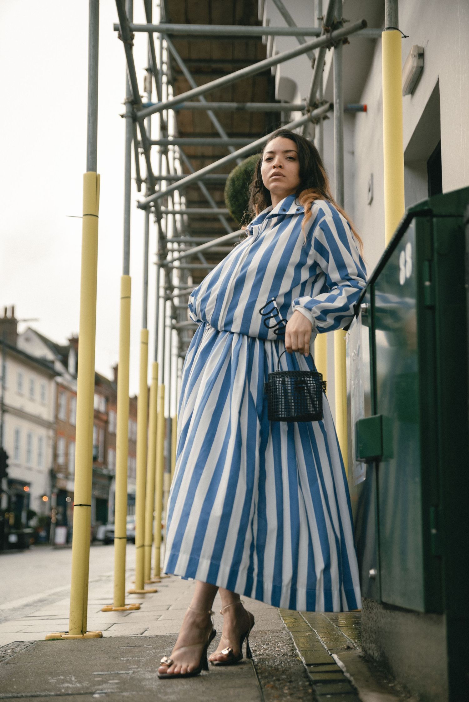 Woman wearing a blue and white dress photographed outdoors for a fashion editorial in Hertfordshire