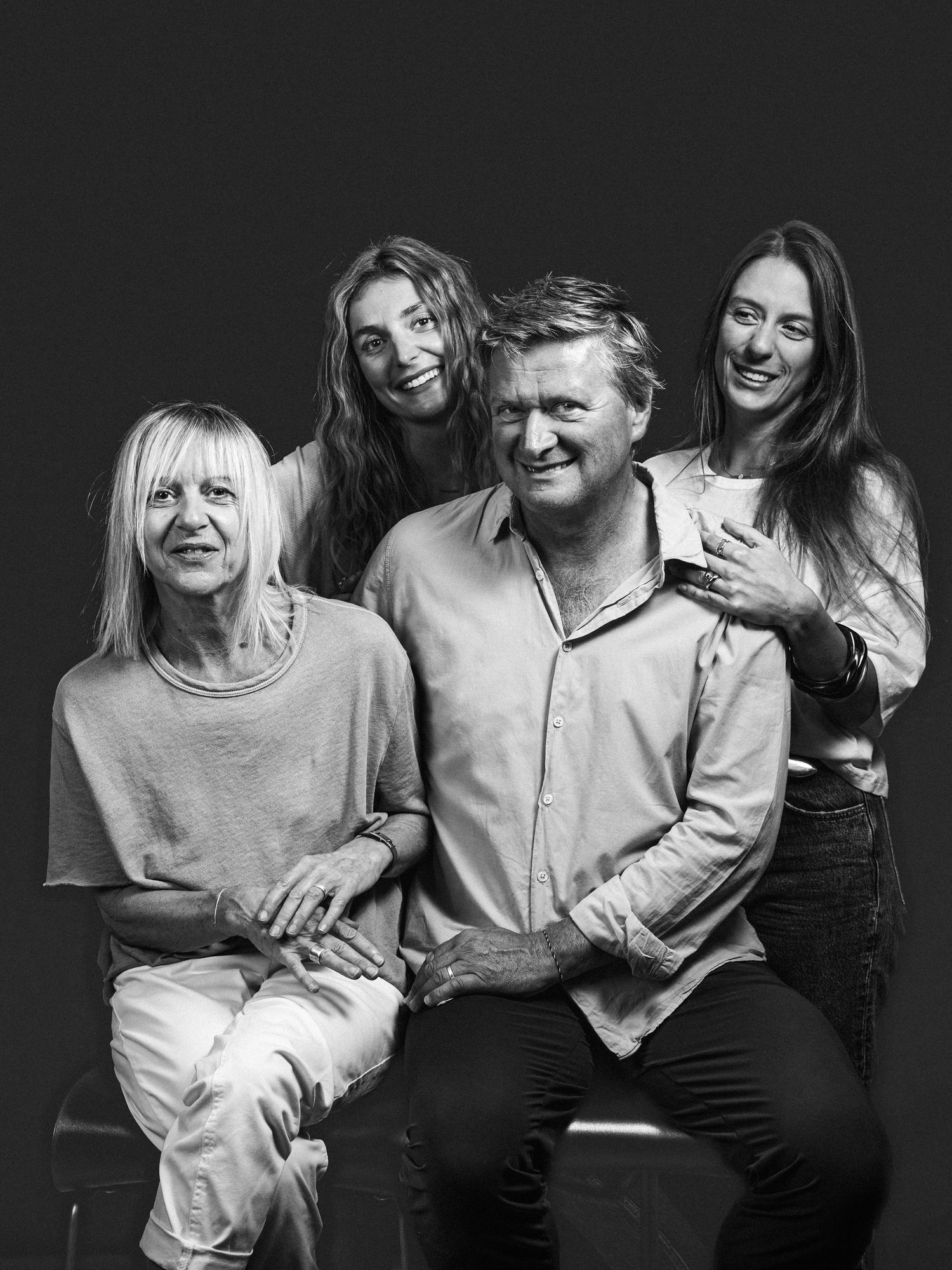 Family of four posing together in elegant black and white studio portrait photograph.