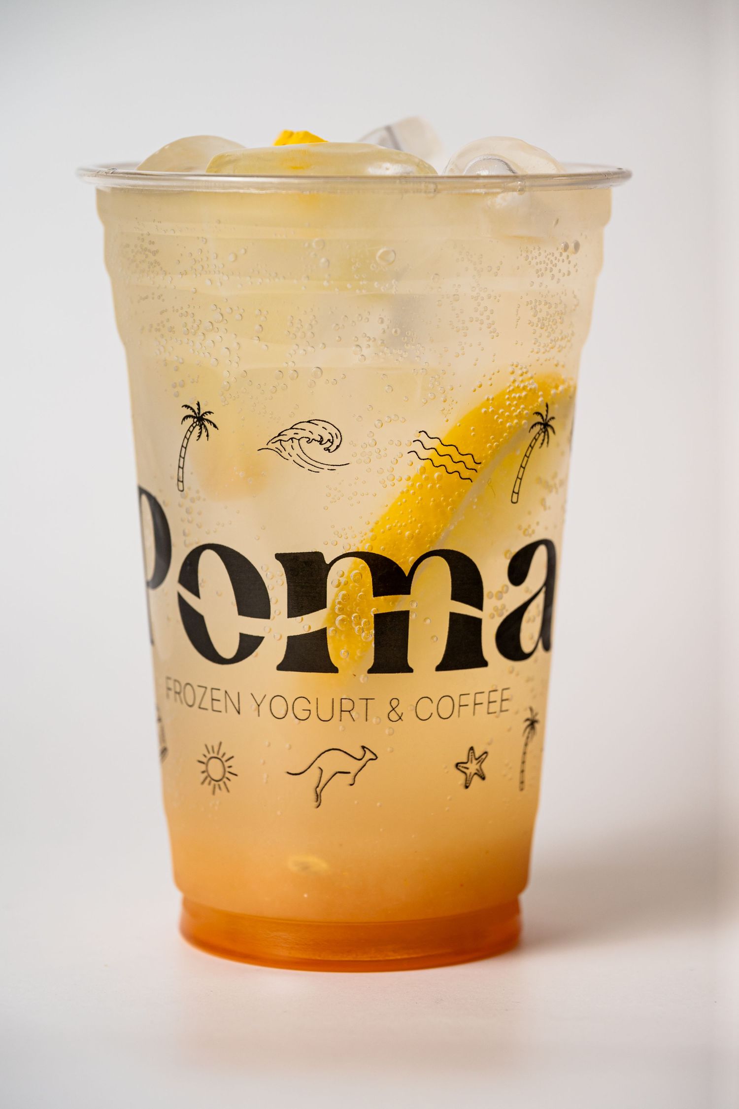 Poma Frozen Yogurt & Coffee iced drink in branded plastic cup with lemon slice on white background.