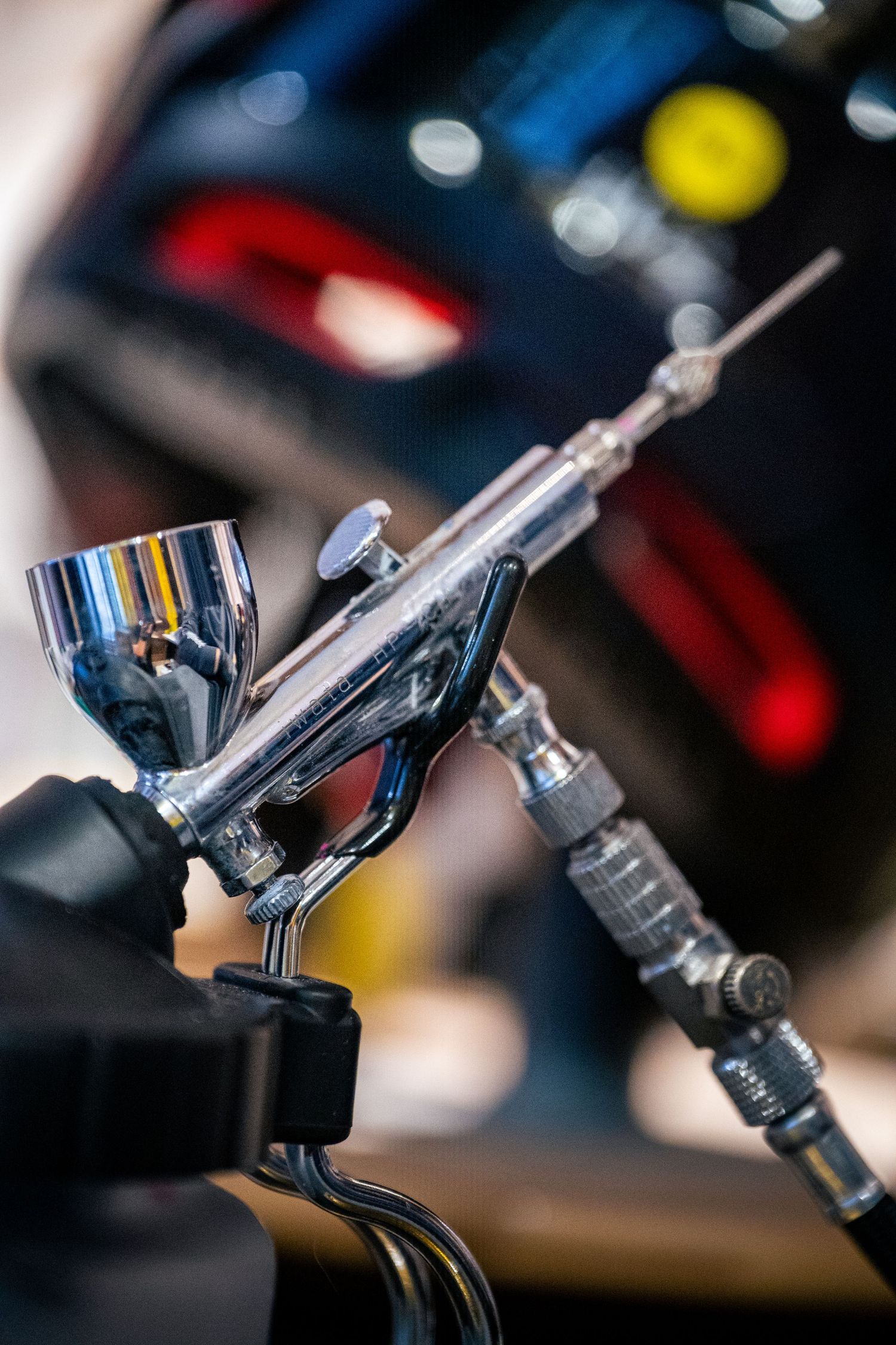 Close-up of a chrome airbrush gun tool used for custom painting artwork.