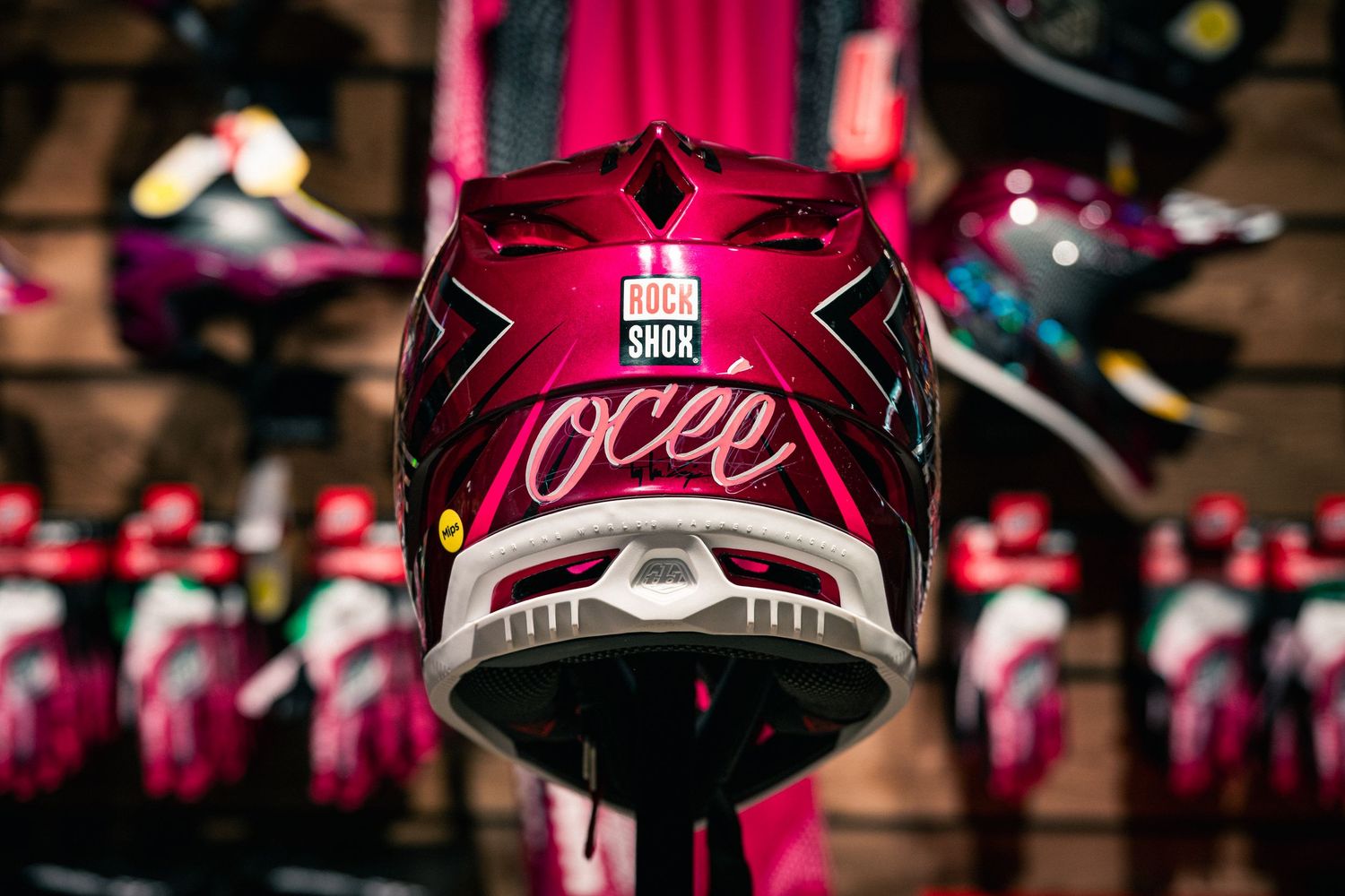 Pink OCee full-face mountain bike helmet with RockShox branding displayed on a store rack.