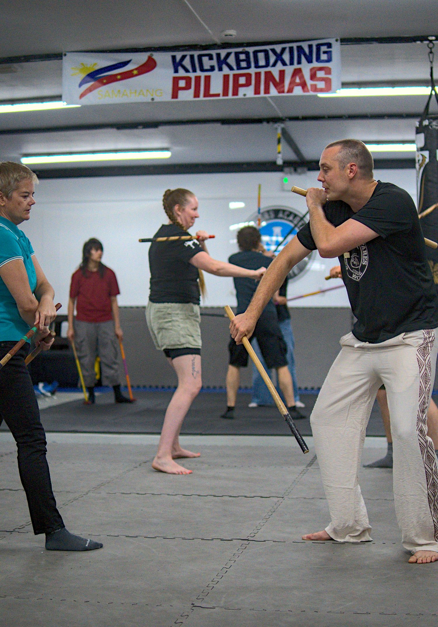 Students practice Filipino stick fighting at a Kickboxing Pilipinas martial arts gym.