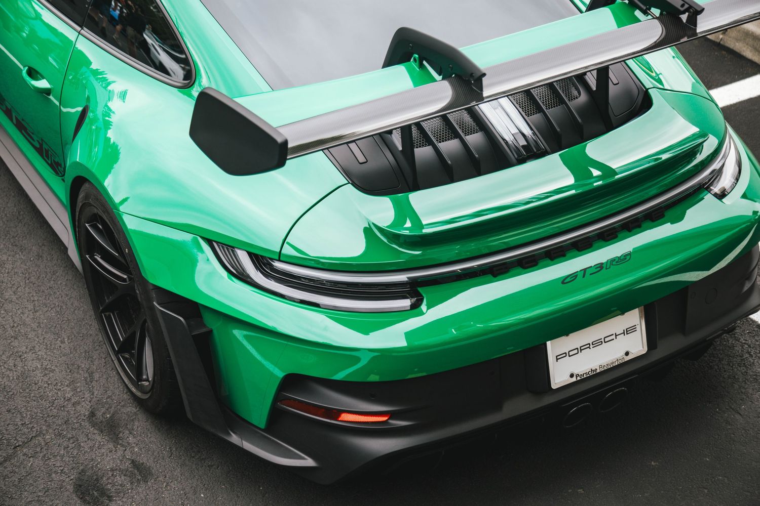 Green 992 Porsche GT3RS rear wing and taillight top down shot at Porsche Beaverton Cars and Coffee.