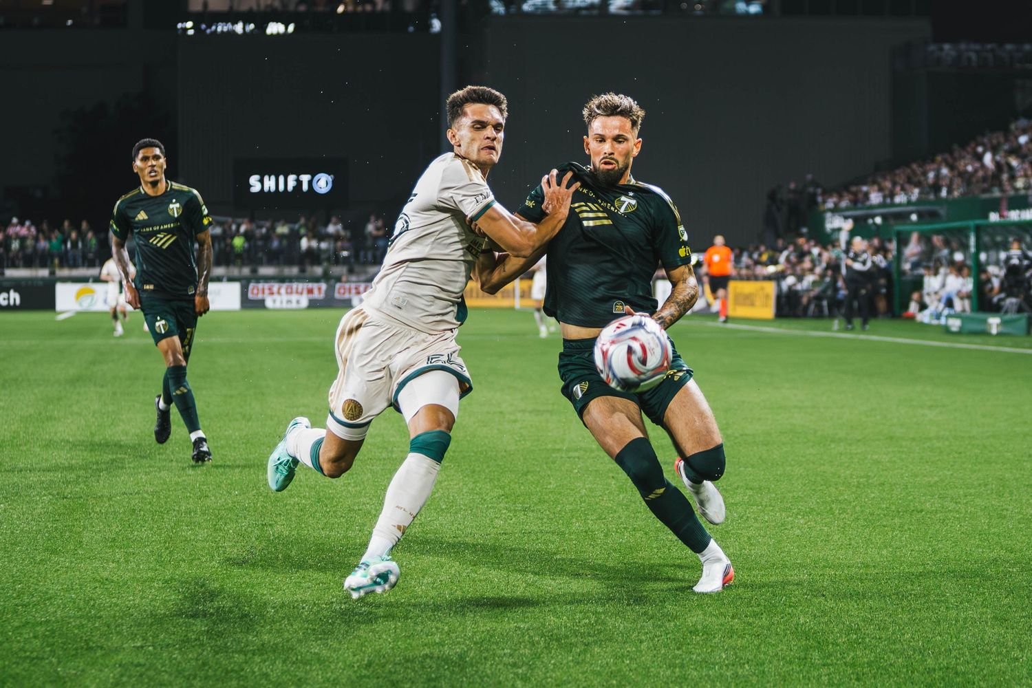 Portland Timbers players competing against Atlanta United FC during a Major League Soccer match at Providence Park in Portland, Oregon.