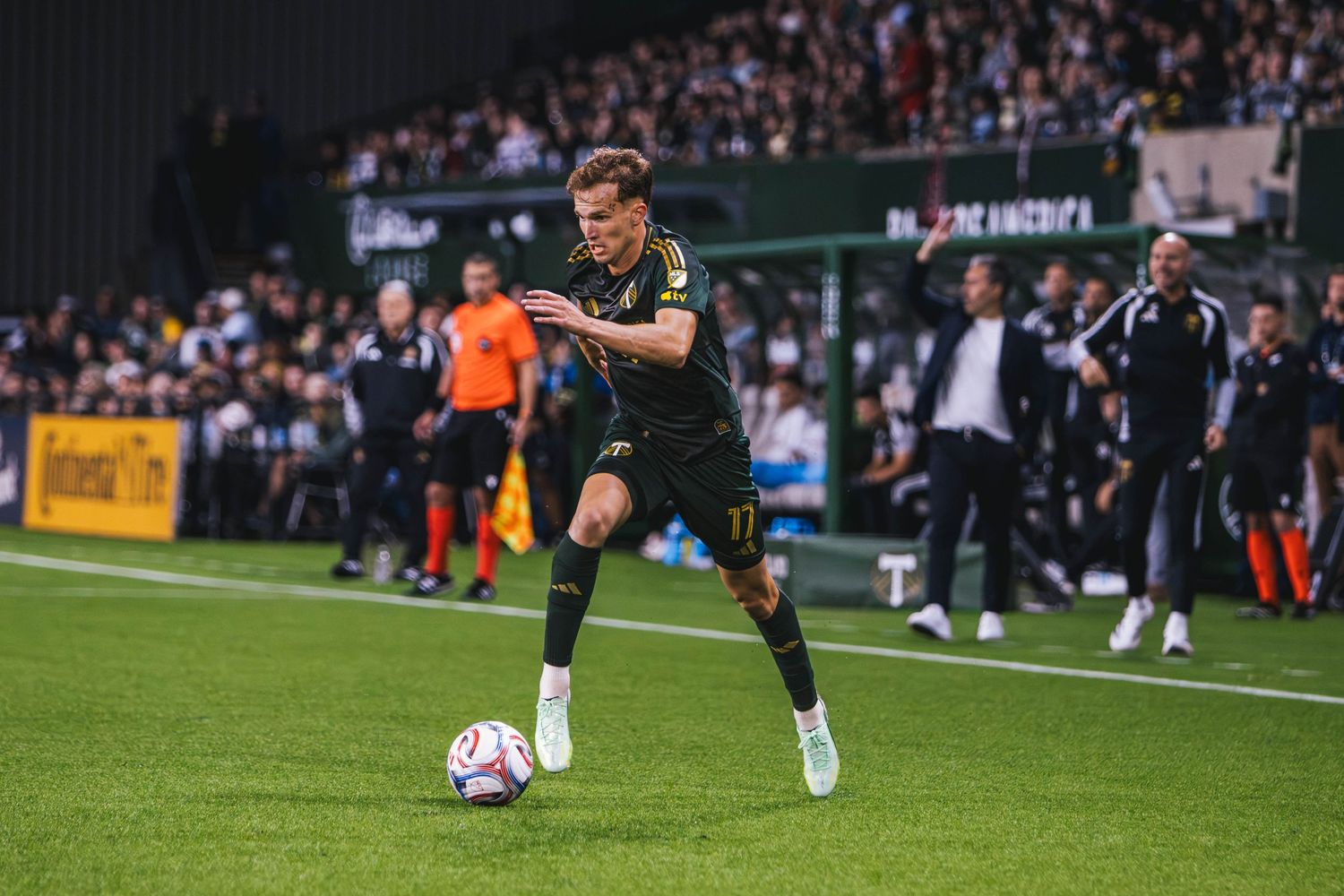 Cole Basset dribbles the ball forward for the Portland Timbers at Providence Park.