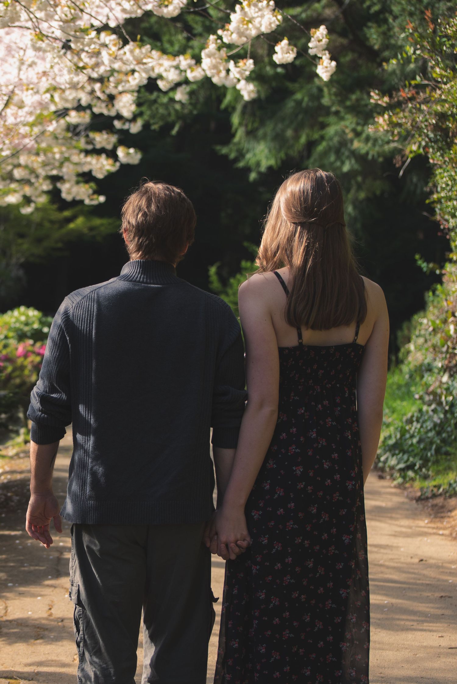 A photo of a couple turned away while holding hands,