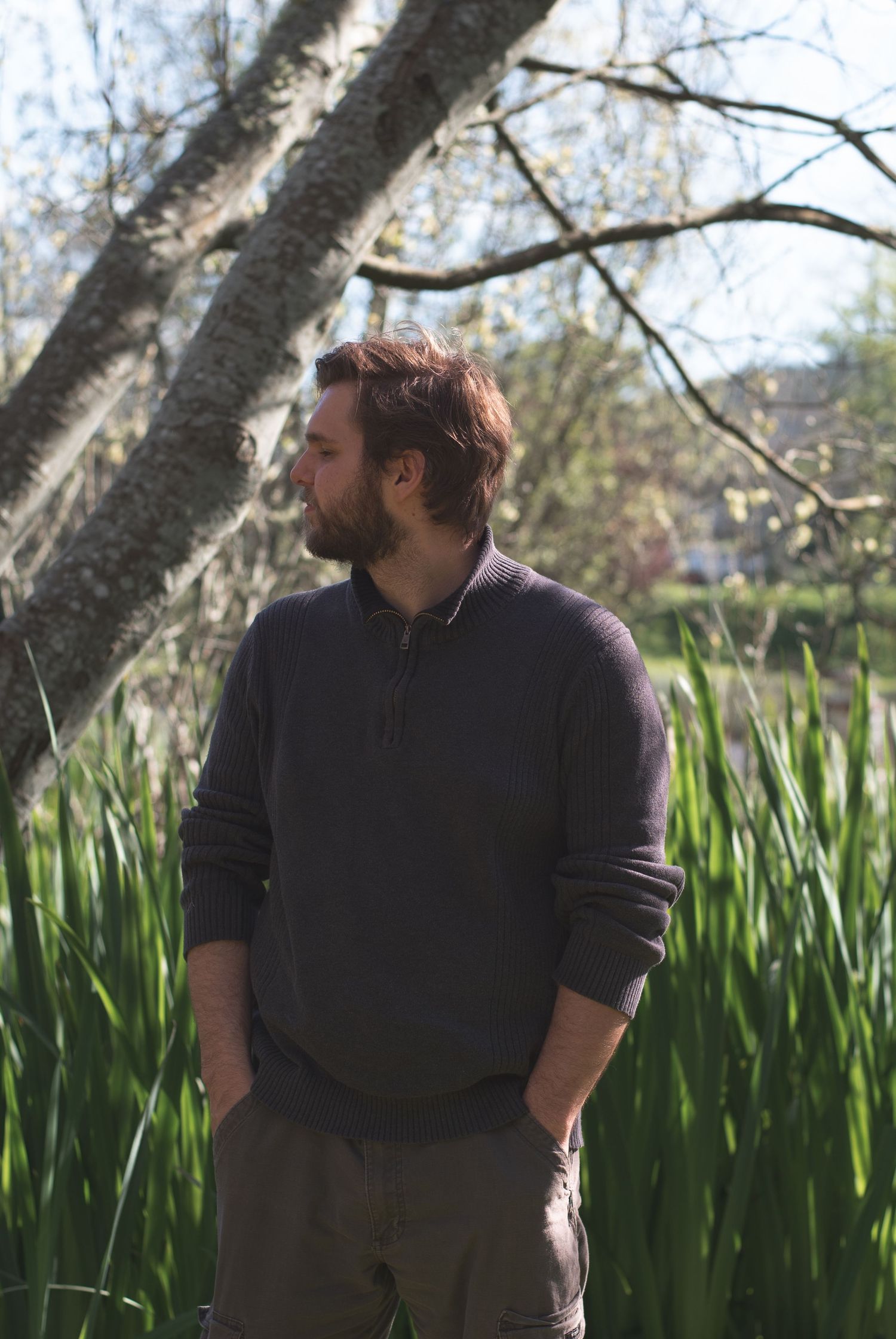 A photo of a man standing in front of a tree.