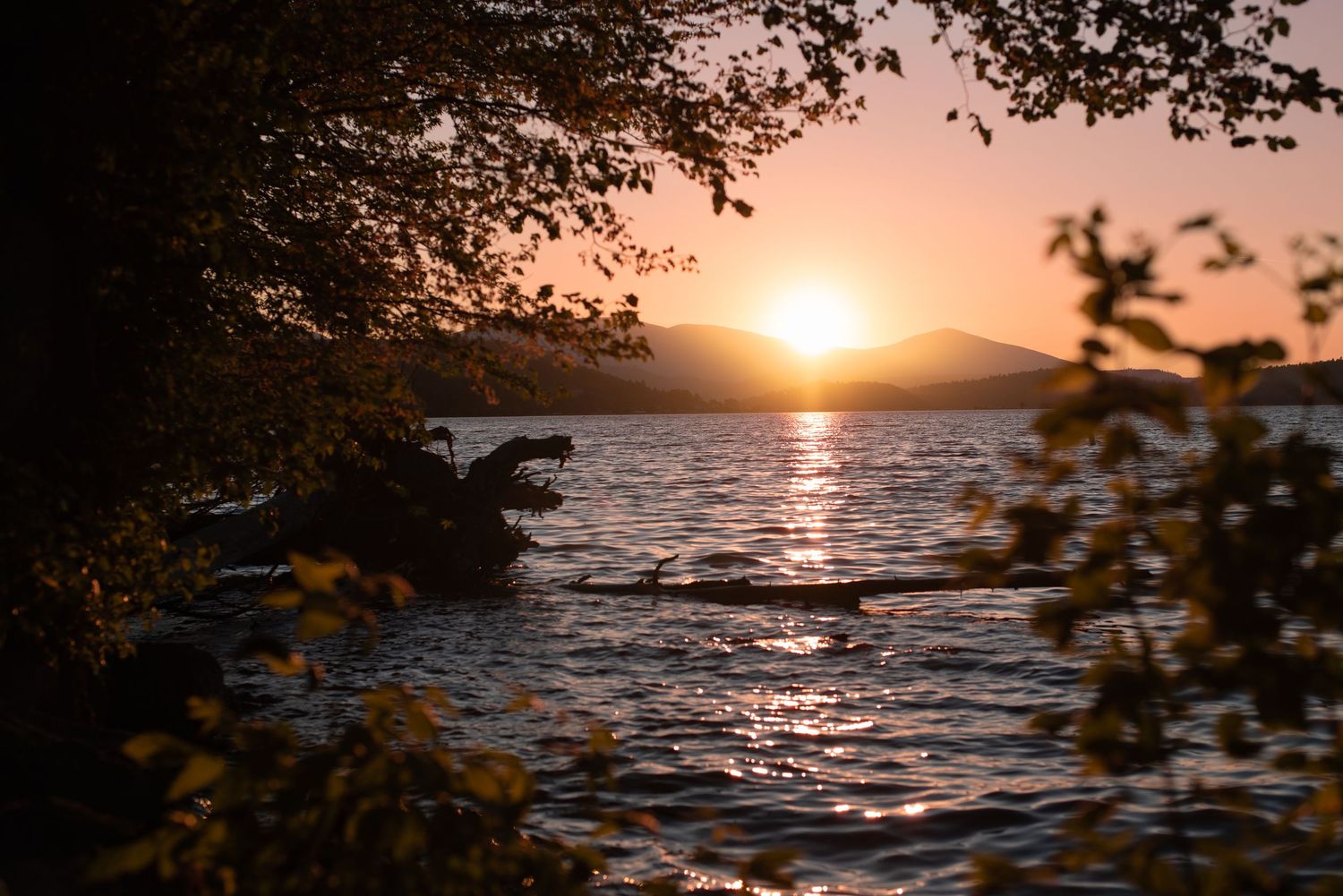 A photo of the sun setting over a body of water.