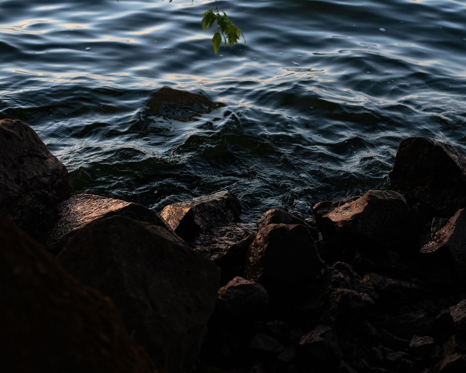 A photo of moving water against rocks.