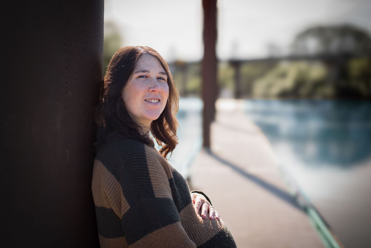 A photo of a pregnant woman on a dock.