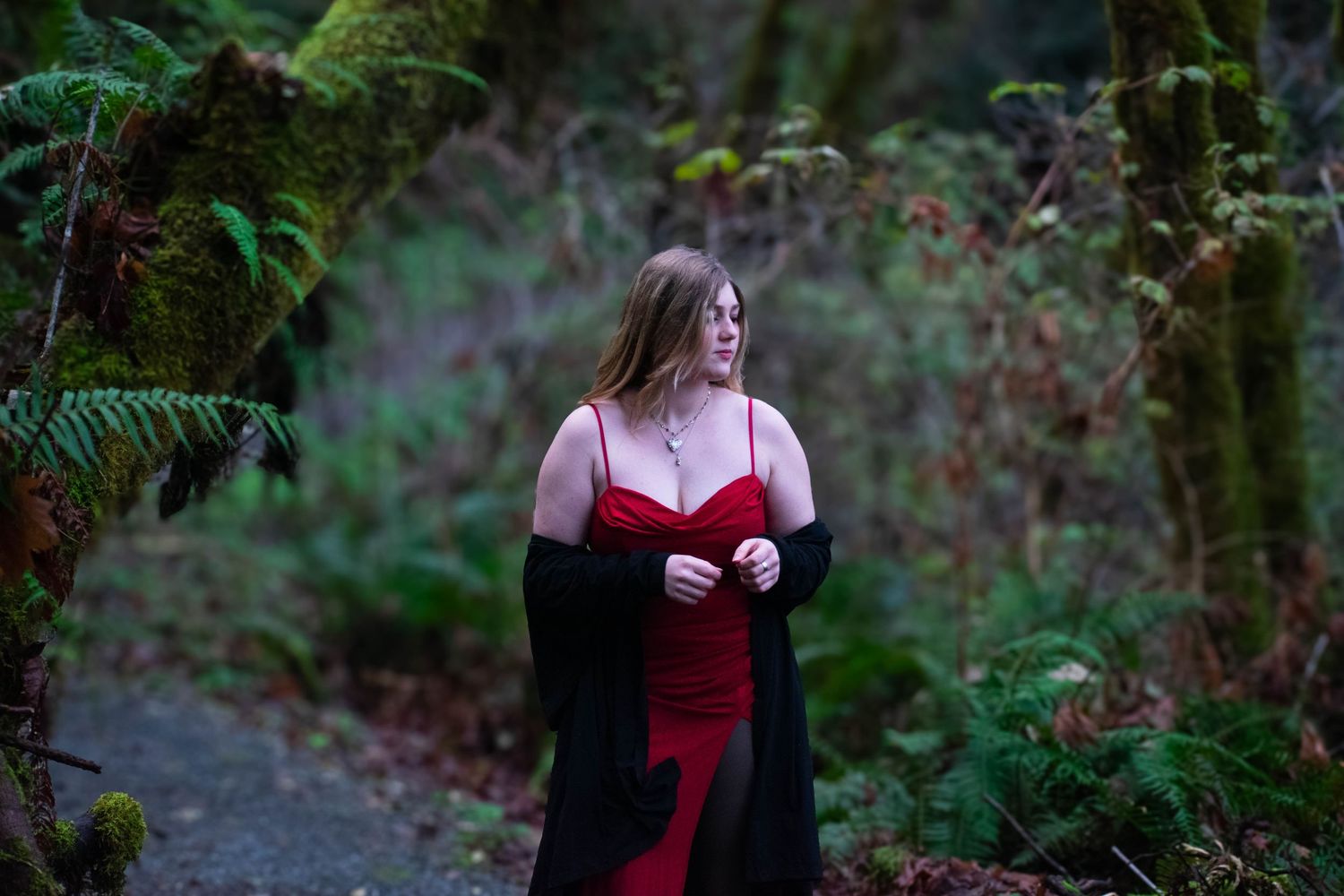 A photo of a woman standing in the forest.