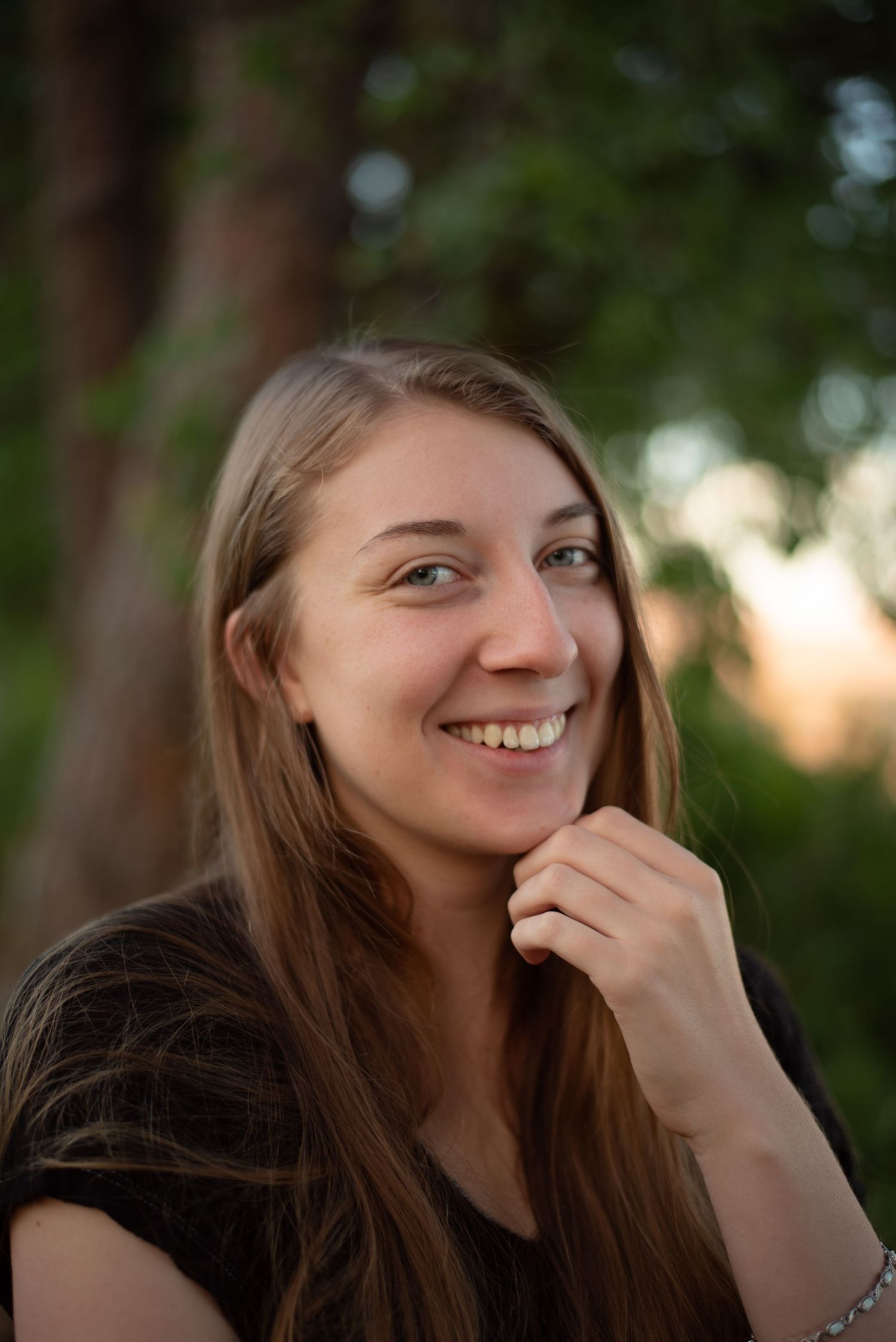 A photo of a woman in front of a tree.