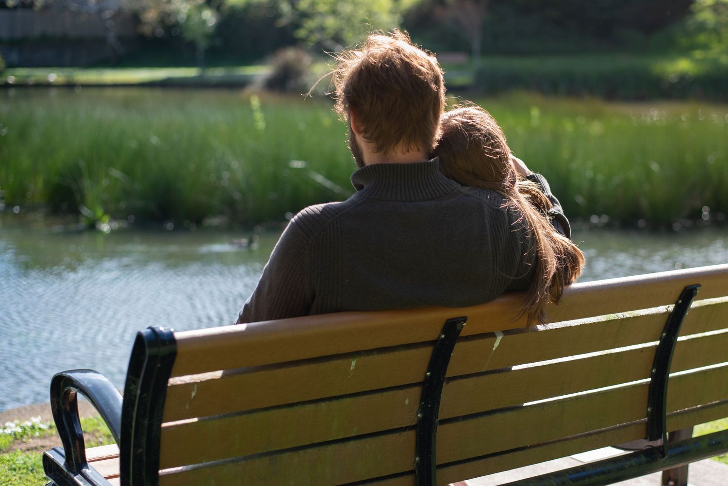 A photo of a couple with the woman leaning on her fiancé's shoulder.