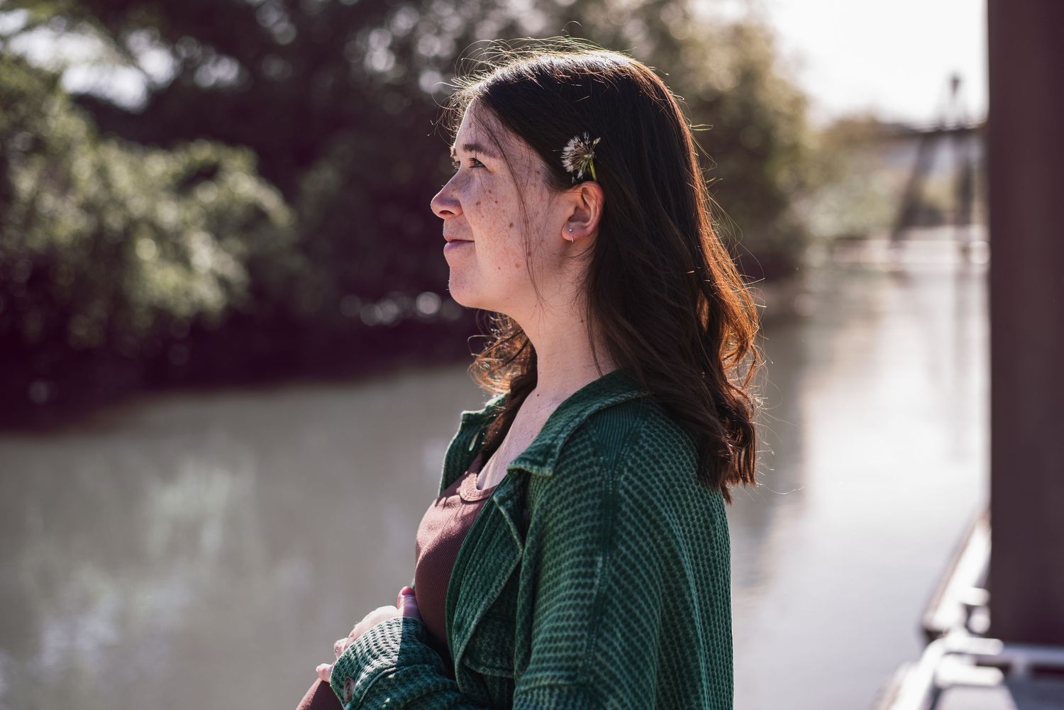 A photo of a pregnant woman looking into distance.