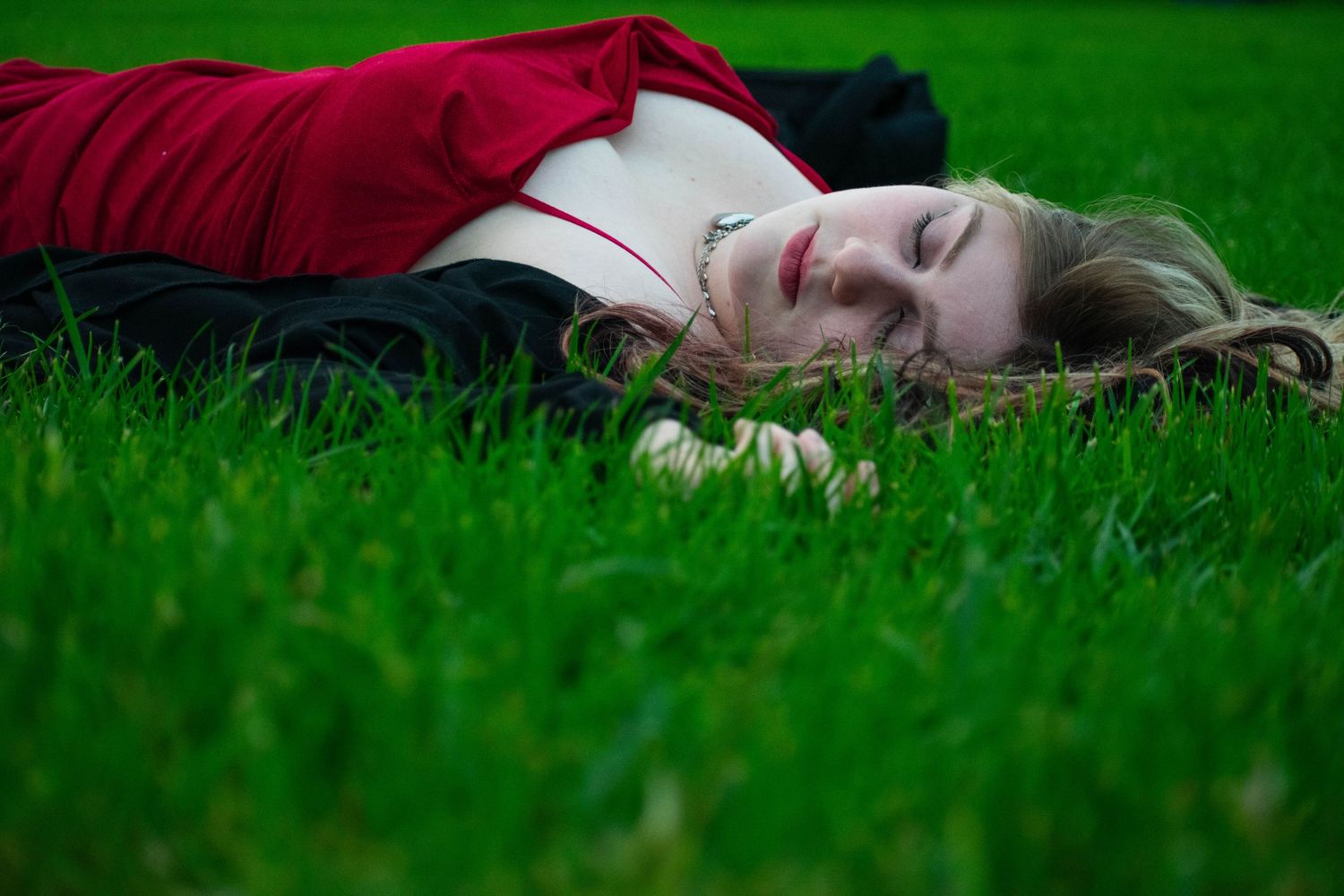 A photo of a woman lying in the grass.