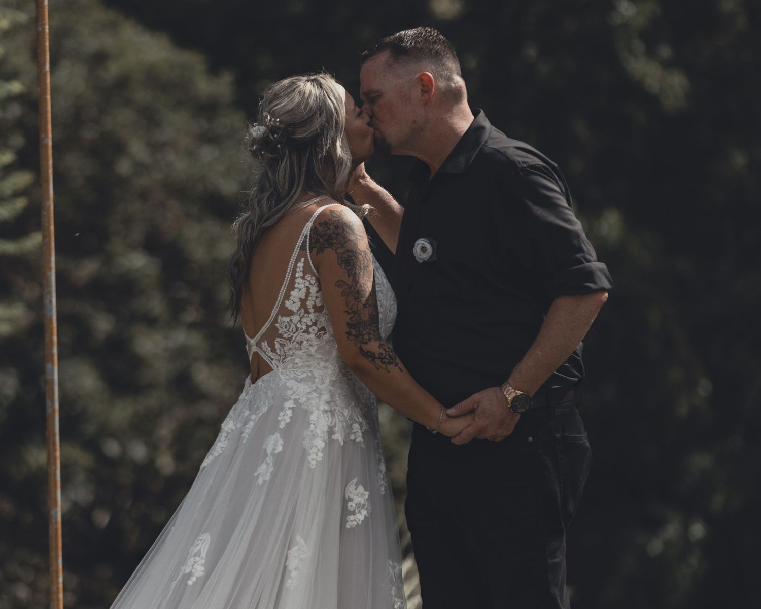 Bride and groom sharing first kiss at outdoor wedding ceremony altar.