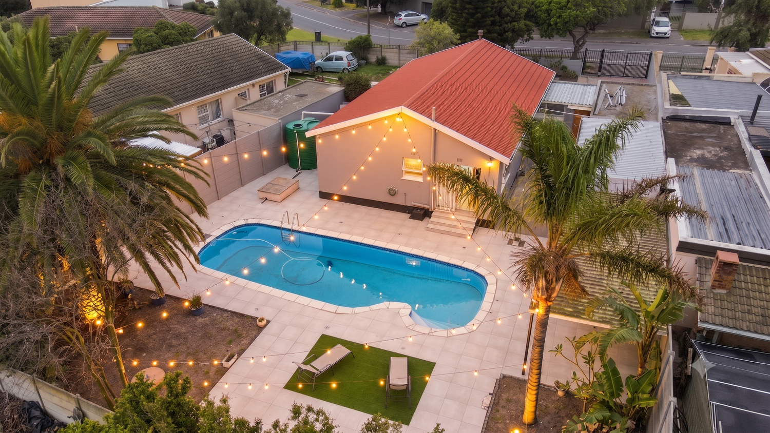 Aerial twilight drone photography of residential home with swimming pool