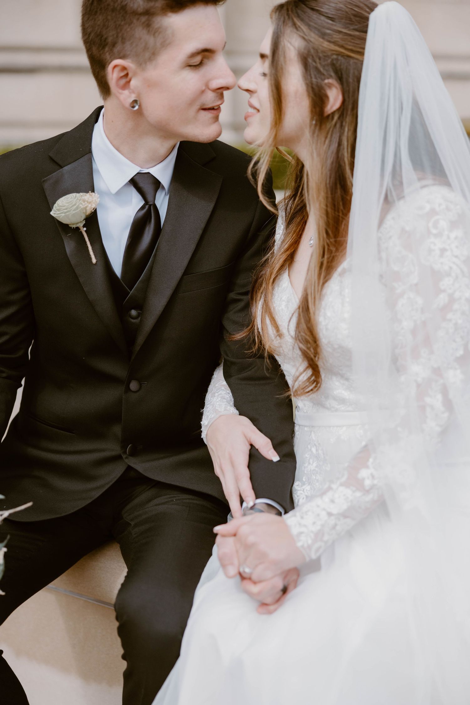 Bride and groom in black suit sitting close together sharing an intimate moment.
