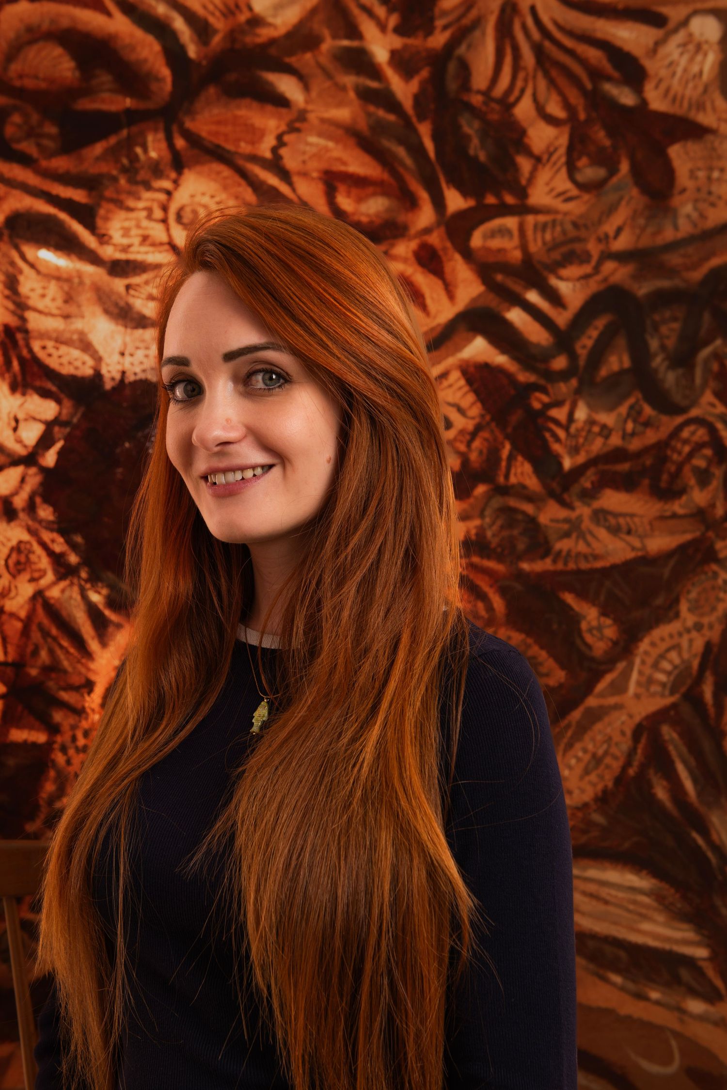 Portrait of a girl with red hair and background with jungle paintings